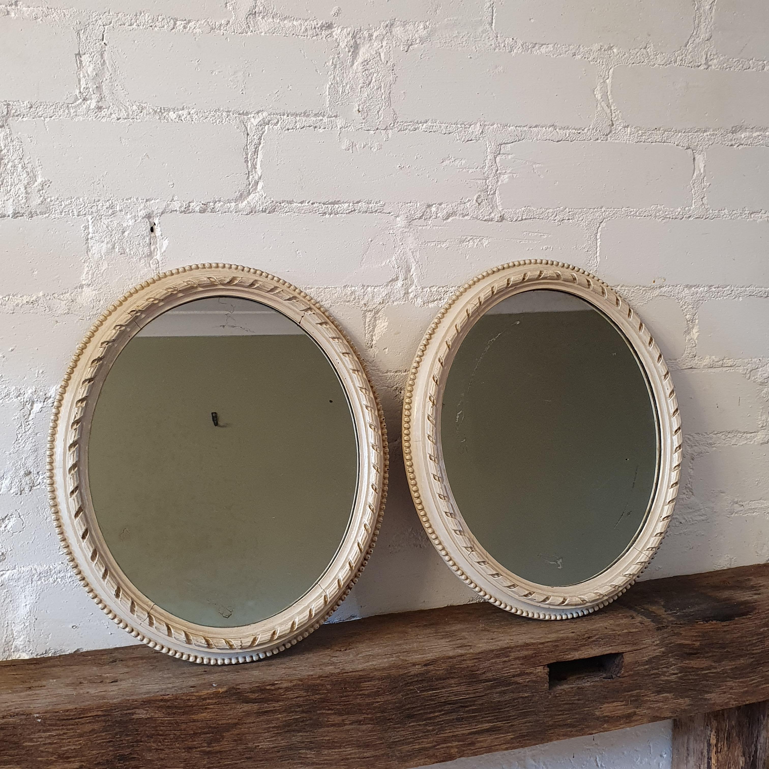 19th Century painted English miniature oval frame mirrors, ivory painted frames with ribbon and stick ornament. Little bead course along the edge. Both frames contain original mercury glass plates with sign of age (some scratches and spots) Very