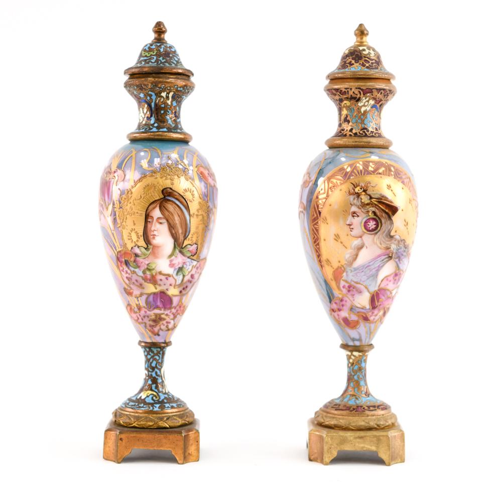 A wonderful combination of porcelain and champleve enamel work on the bronze these are a fantastic pair of mini urns that would draw attention to any shelf!