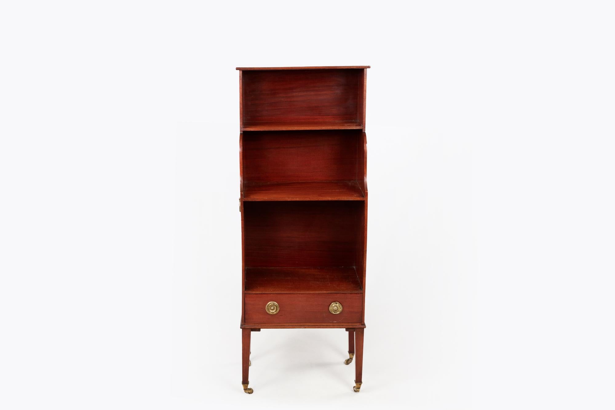 Pair of miniature mahogany Regency era waterfall bookcases with brass castor feet, brass handles, two graduated shelves & single drawers below.