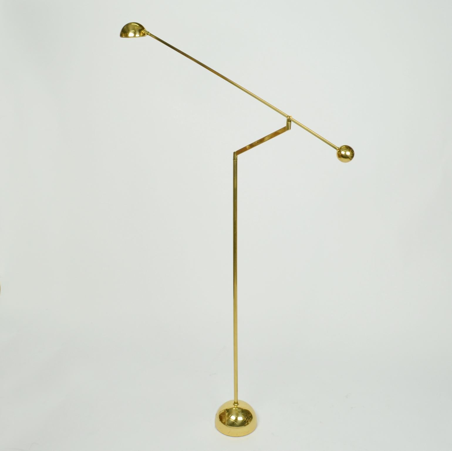Pair of brass minimalist counterbalance floor lamps are super flexible, with an arm adjustable to 180 degrees. The halogen light source is attached to a long arm holding a spherical counter weight. The arm sits on an angled stand with counter