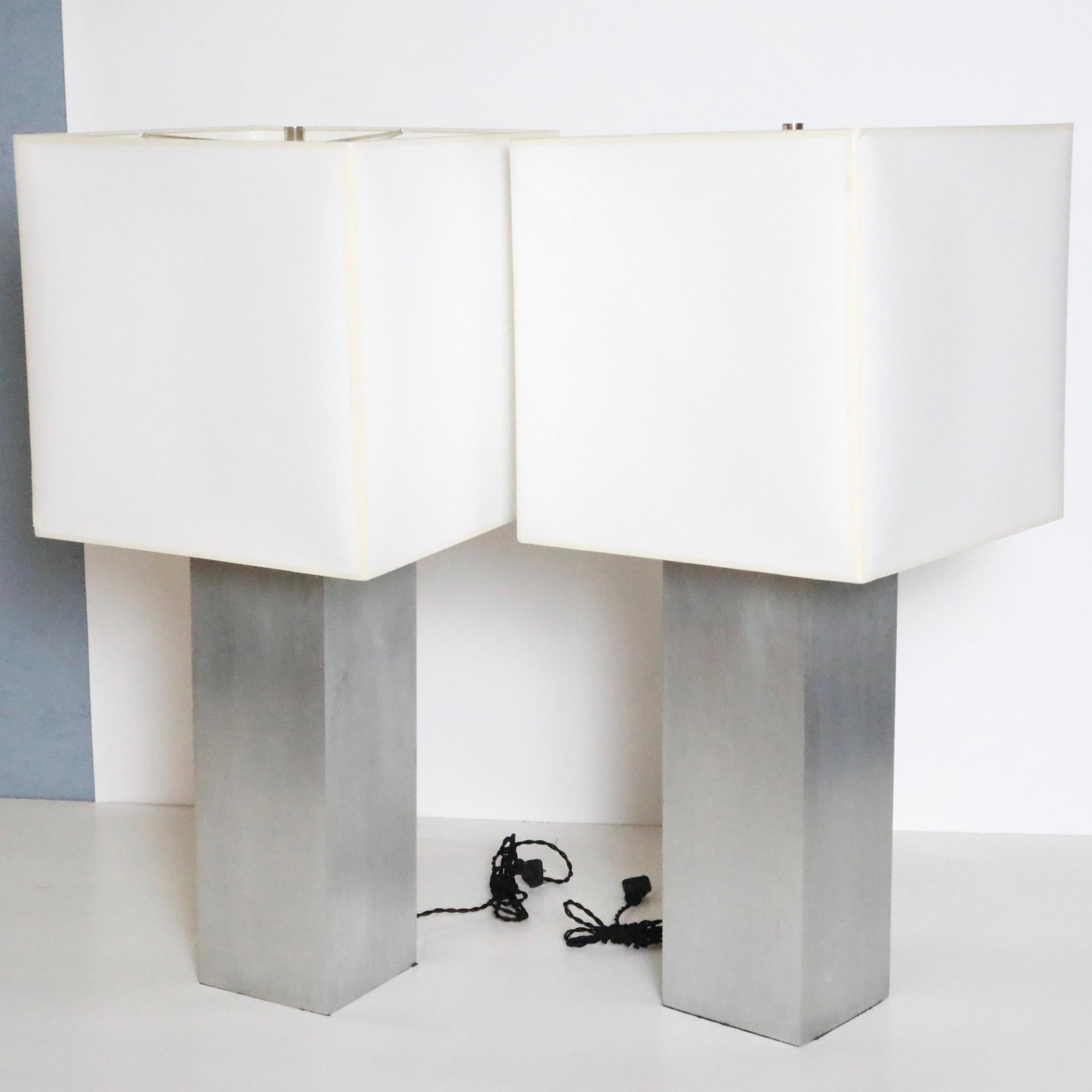 A Minimalist and clean-lined pair of vintage table lamps with a brushed metal rectangular base and custom off-white square-shaped paper shades.

USA, circa 1970.

Dimensions:
Overall: 31.5 inchs H x 14 inches W
Base: 6 inches L x 6 inches D
Shade: