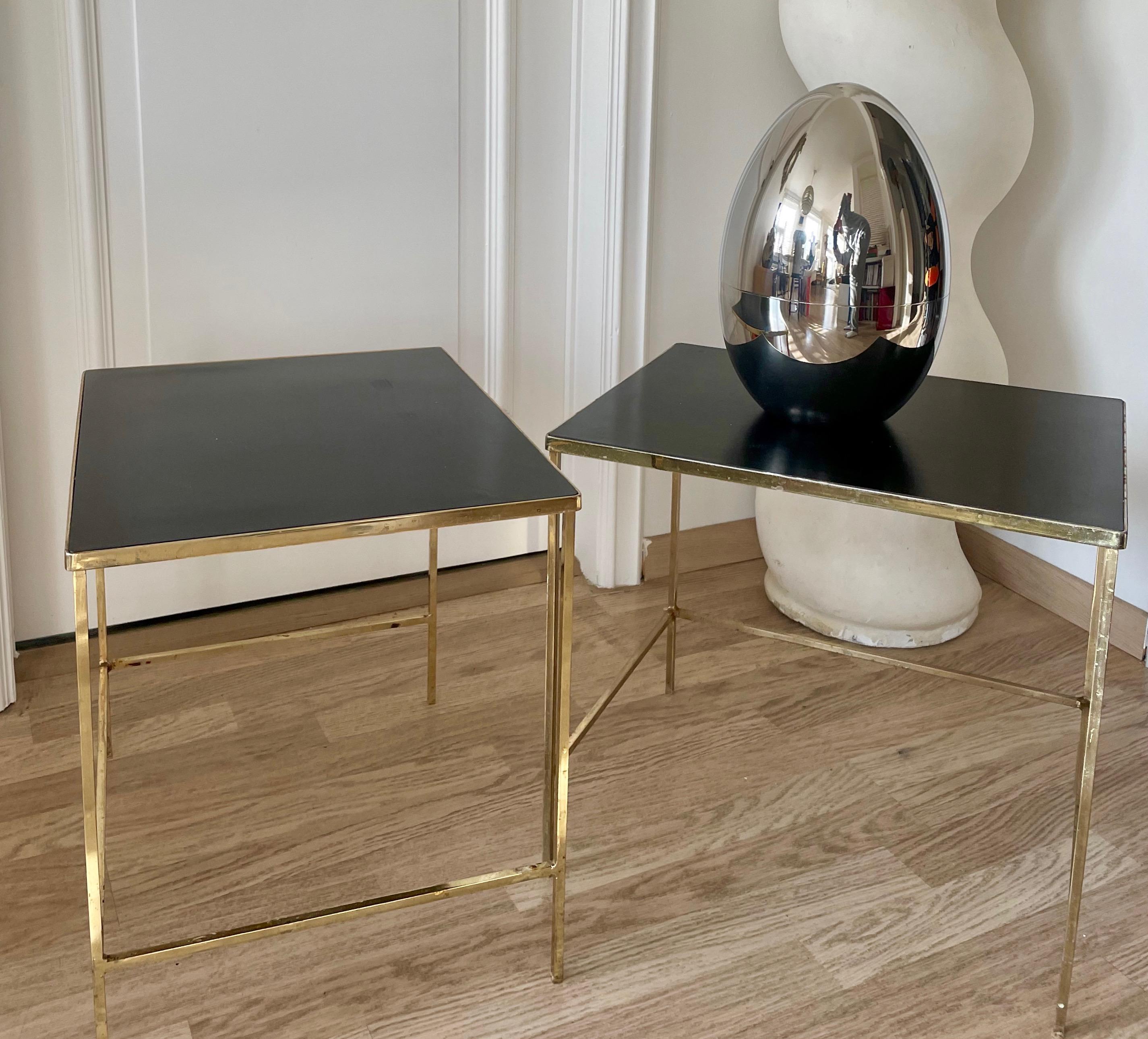 Pareja de mesas auxiliares minimalistas de metal dorado con tablero de formica negra.
Francia, 1970.