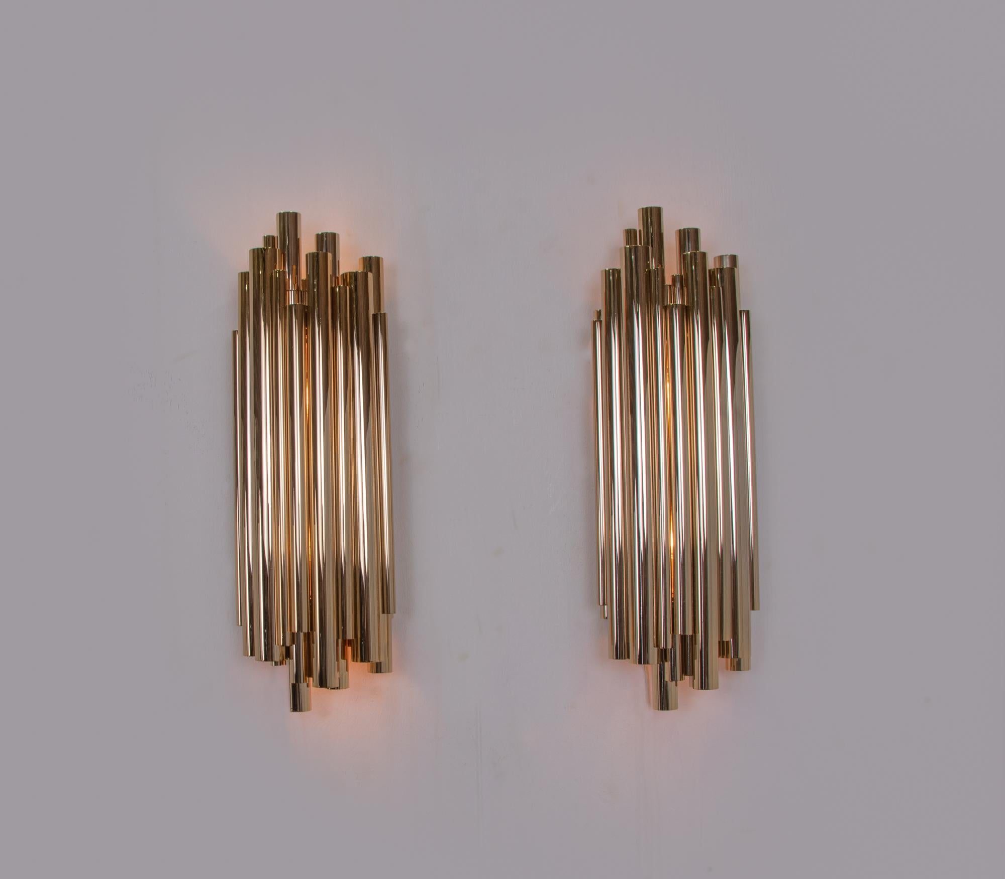 Elegant miminalist pair of large wall lights in handcrafted solid brass with gold-plated finish. These extraordinary lights were inspired by a pipe organ. These wall lamps emit a pleasant indirect light into the room and set accents even when unlit.