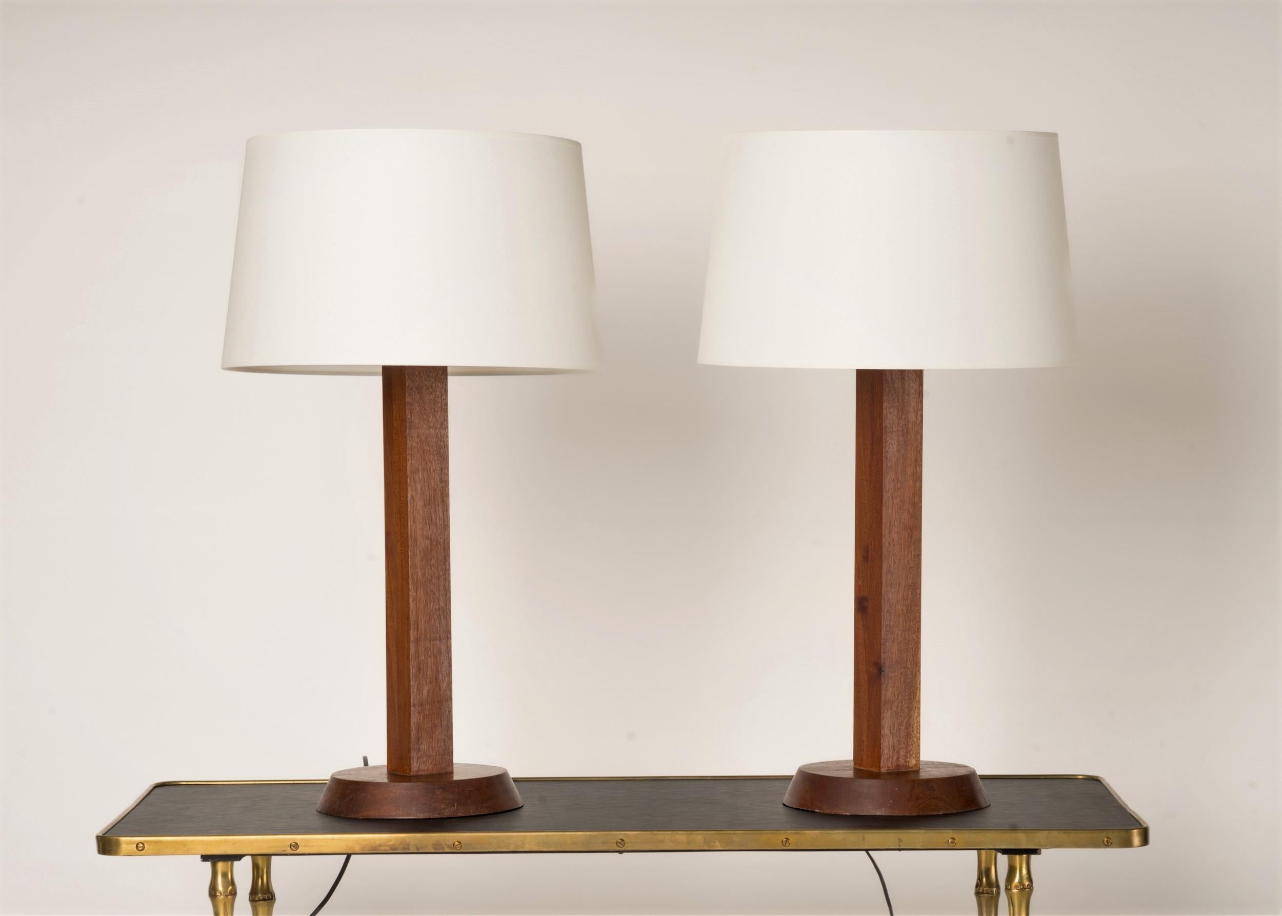 Pair of elegantly crafted table lamps made of solid wood.  The inclined based features a diameter difference between the top and bottom levels which adds a subtle design touch to them.
European sockets and wiring.
These lamps will ship from France