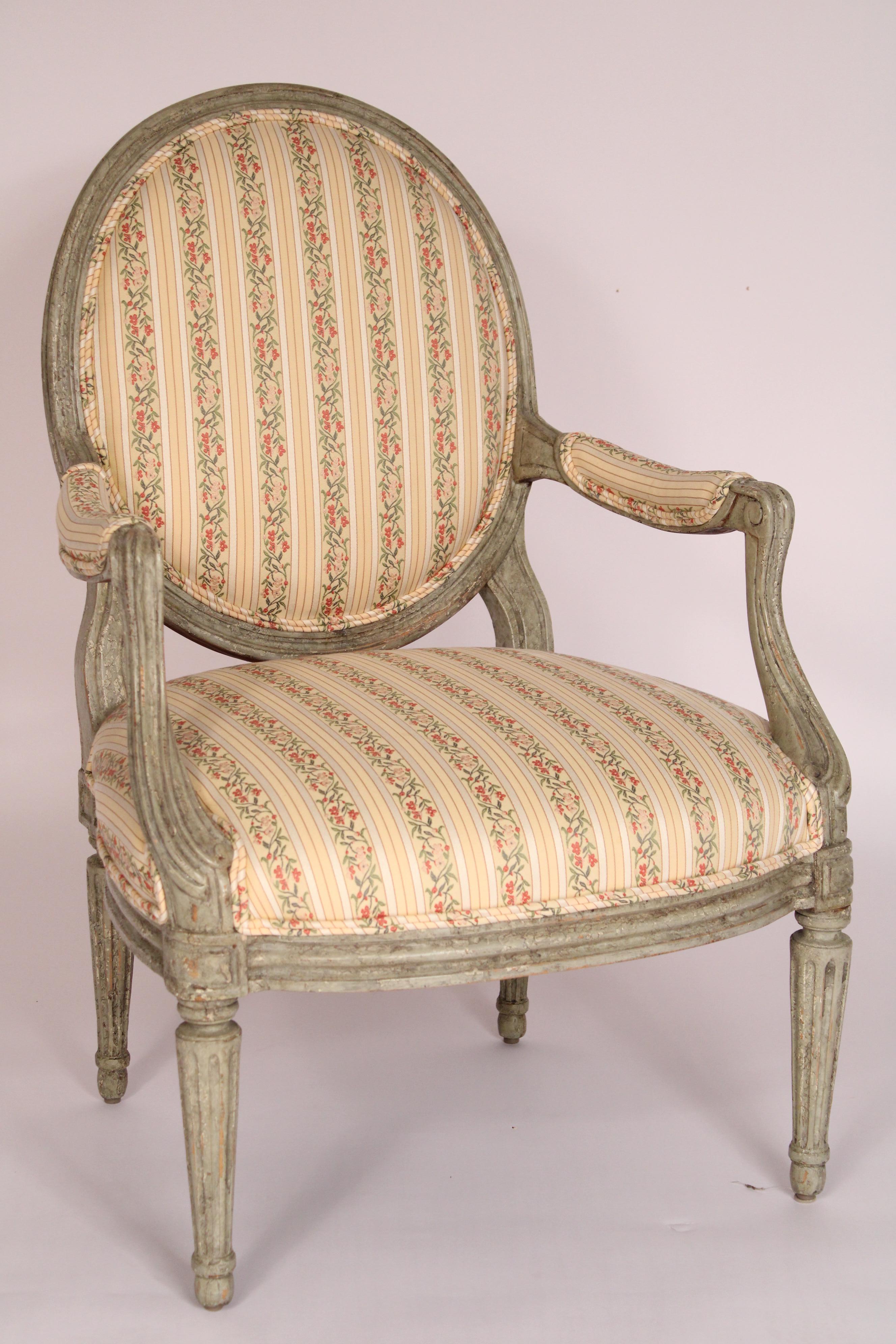Paire de fauteuils de style Louis XVI peints en grisaille, réalisés par Minton-Spidell, vers 2000. Dossiers ovales et moulurés, assises confortables, accoudoirs en bas, pieds tournés, fuselés et cannelés. Profondeur de l'assise 21