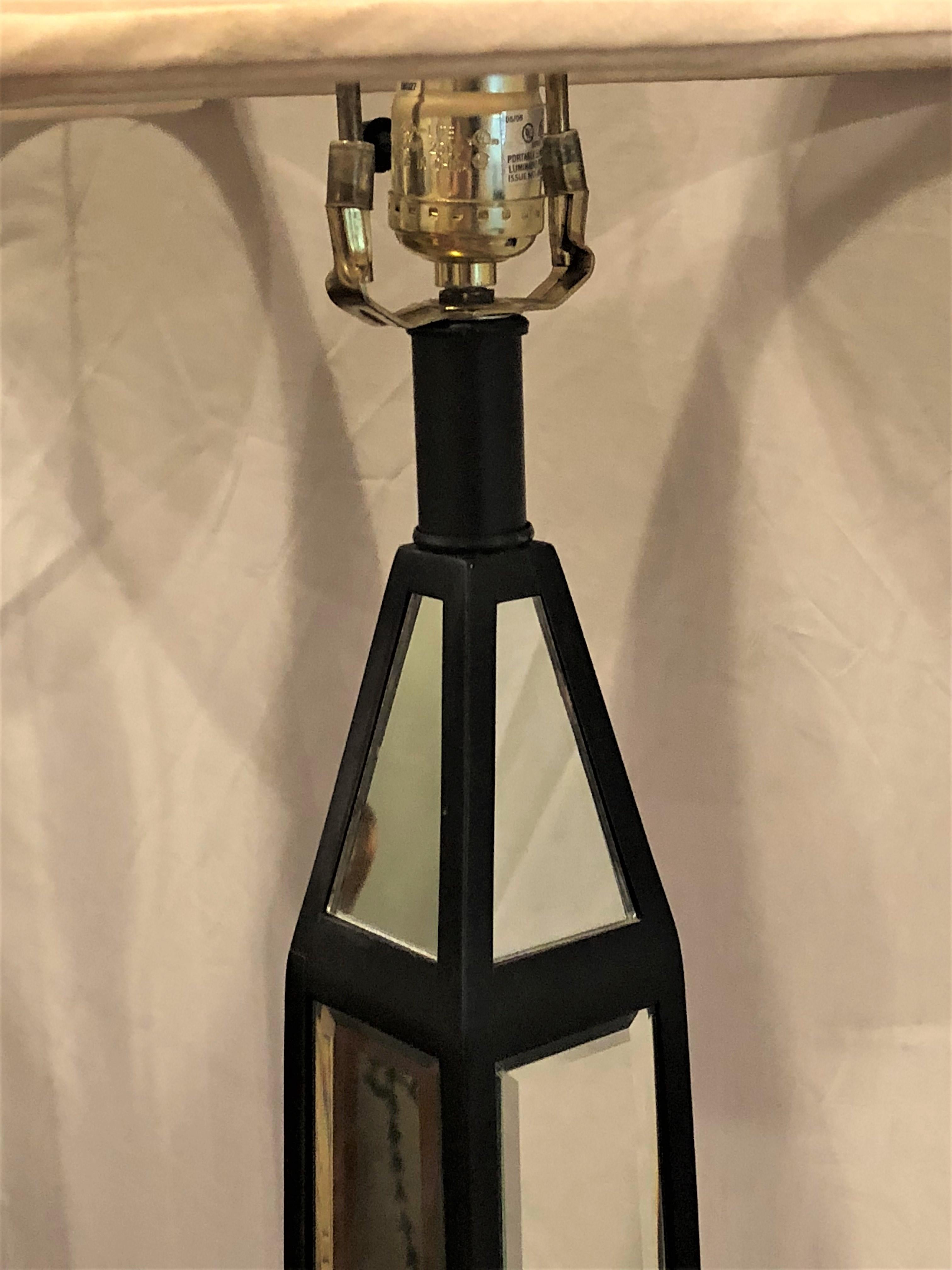 A pair of mirror and ebony obelisk style floor lamps.