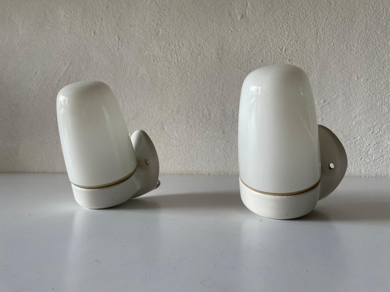 Opal Glass and Porcelain Bauhaus Pair of Mirror Sconces by Wilhelm Wagenfeld for Lindner, 1950s, Germany

Very elegant and Minimalist wall lamps
Lamp is in very good condition.

These lamps works with E27 standard light bulb. 
Wired and suitable to