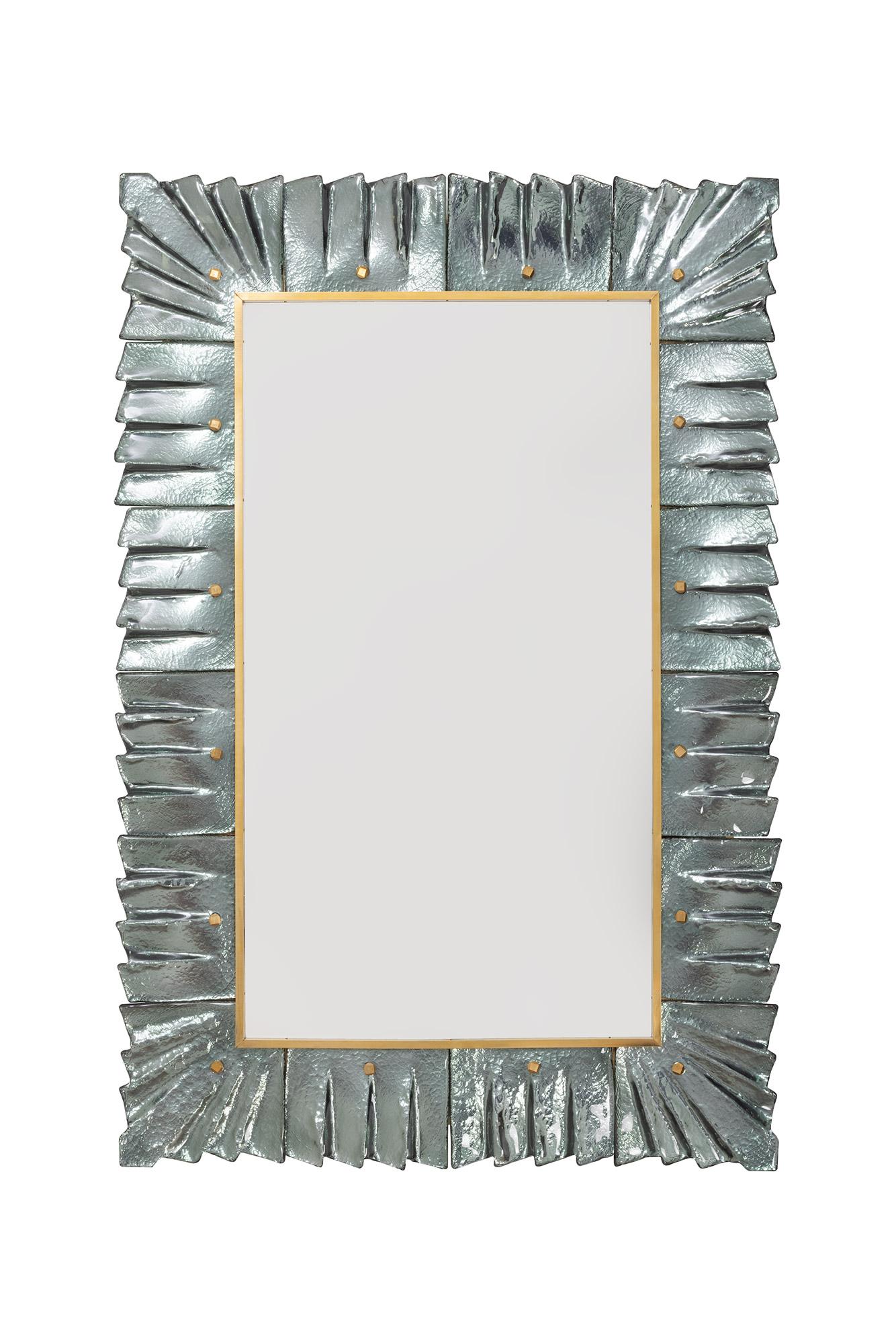 Paire de miroirs encadrés en verre vert de mer sarcelle de Murano, en stock.
Plaque de miroir rectangulaire entourée de carreaux de verre ondulés de couleur vert de mer retenus par des cabochons en laiton. 
Fabriqué à la main par une équipe