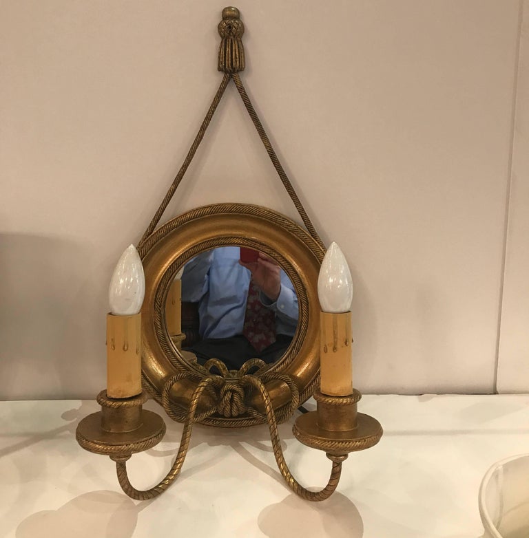 A pair of giltwood and gilt metal wall sconces with mirrored backs. The round framed backs with mirrors with rope style metal arms supporting two candle lights. The sconces with custom silk shantung pleated detailed shades. NYC, circa 1910.