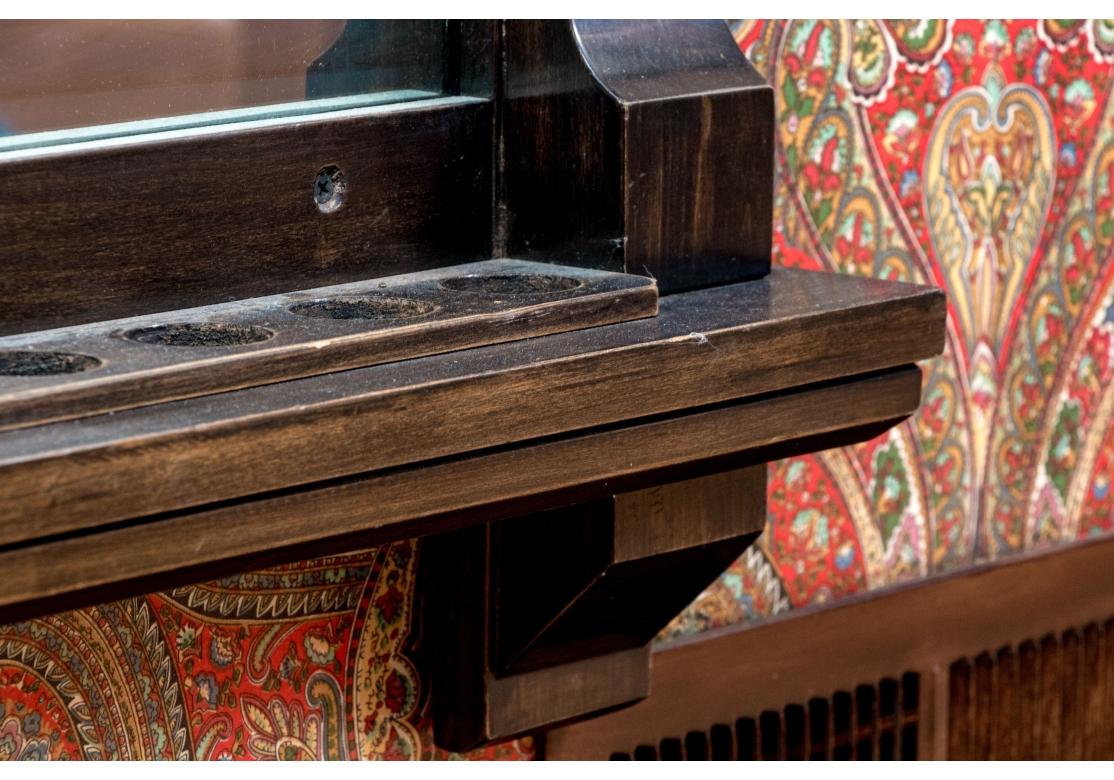 Une paire majestueuse de supports de queues de billard et de comptoirs de points en bois de qualité fini brun foncé, mettant en valeur des frontons sculptés ornés de feuilles d'acanthe et de feuillages en volutes sur des plateaux moulés droits avec