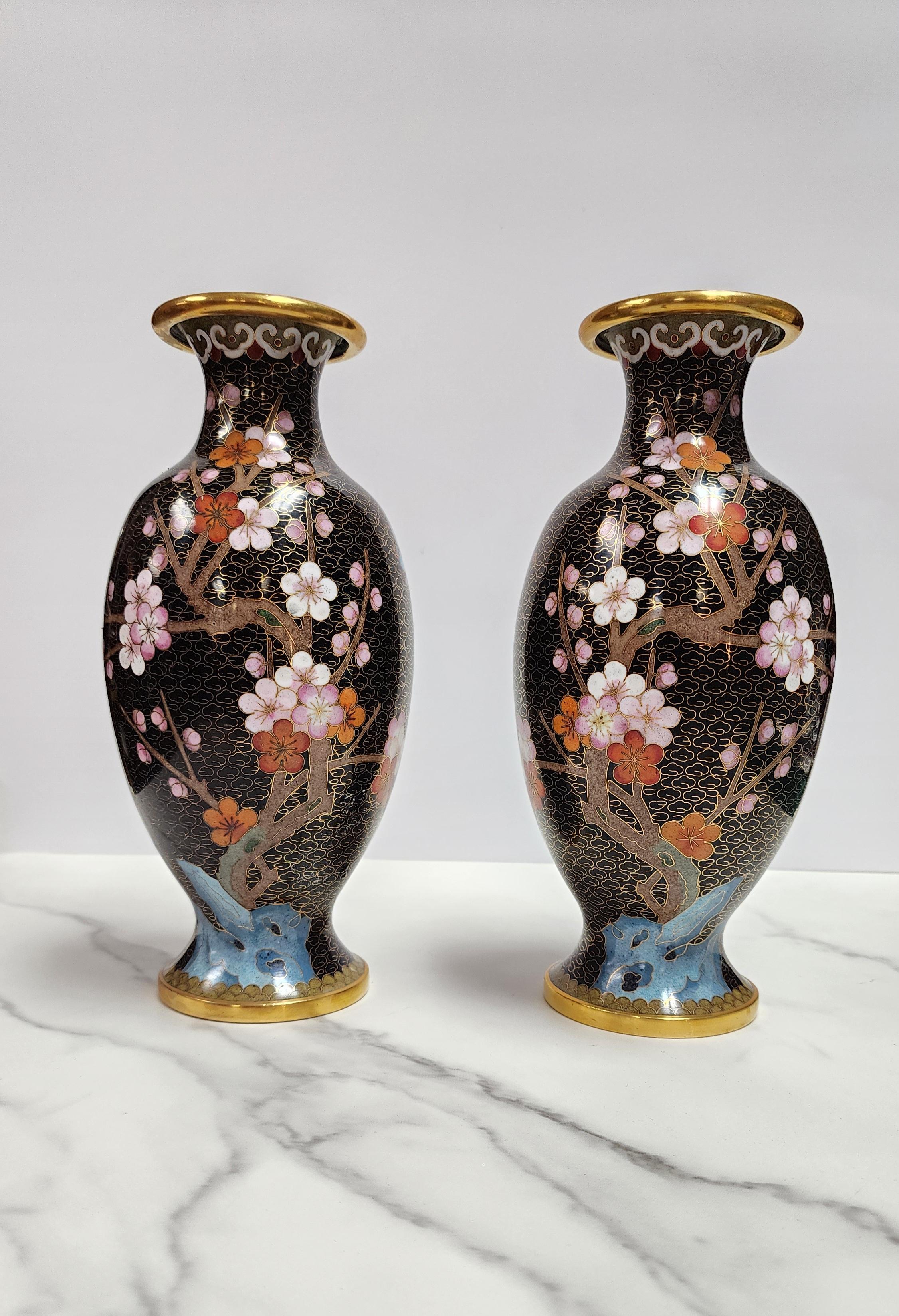 Dieses seltene Paar chinesischer Cloisonne-Emaille-Vasen ist insofern ungewöhnlich, als sich das Design von einer Vase zur anderen perfekt spiegelt. Zu den Blumen- und Vogelmotiven gehören Kirschblüten, eine weiße Rose und ein blauer Vogel. Die