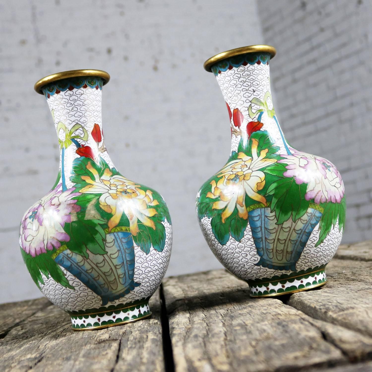 Beautiful pair of 20th century vases in white with multicolored floral and butterfly mirrored design. This pair is in fabulous vintage condition, circa 1960s-1980s

What a gorgeous pair of midcentury cloisonné vases! Their background color is a