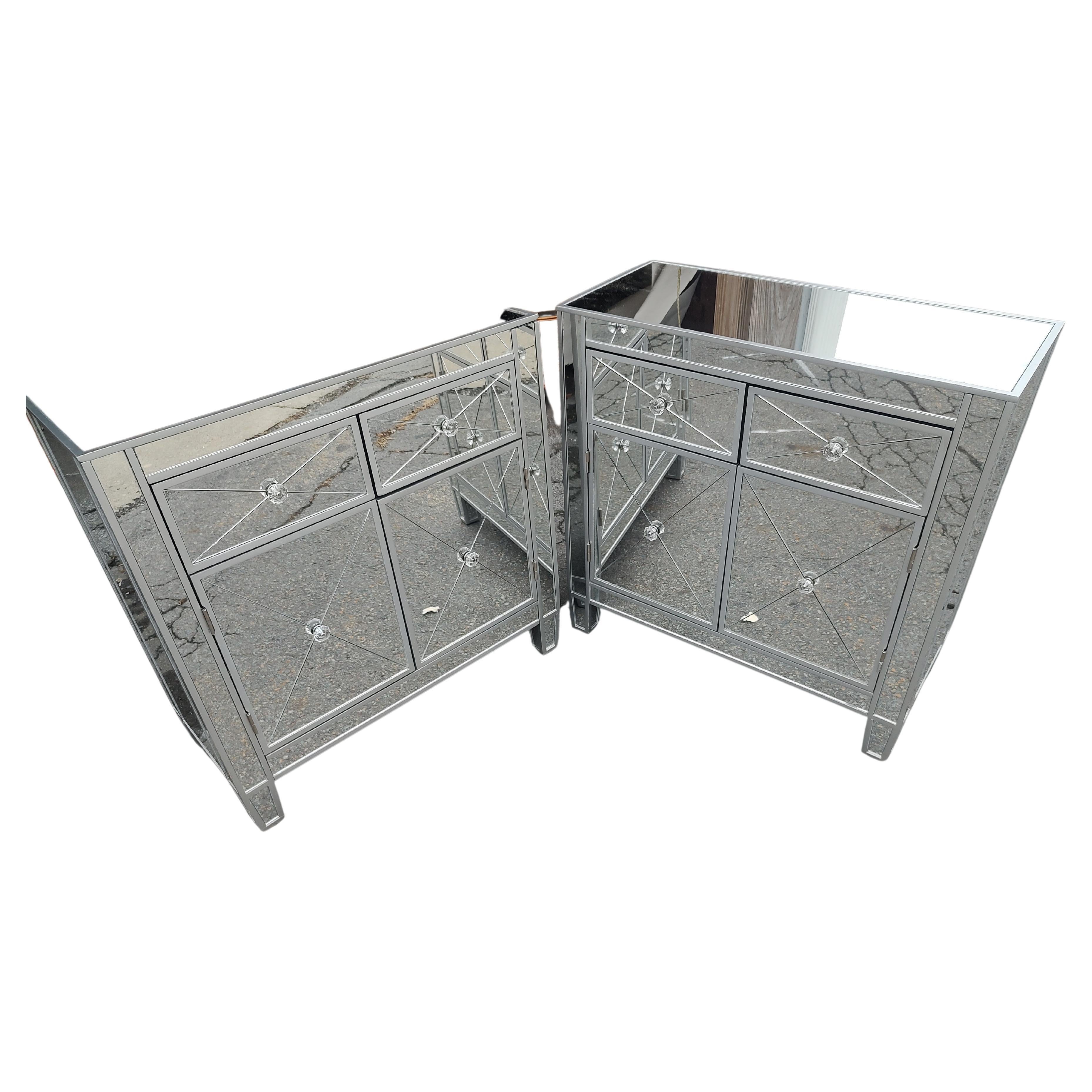 Fabulous pair of fully mirrored night tables with silver leaf trim. Two drawers over two doors supply ample storage space. Glass knobs and etched drawer and door fronts. In excellent used condition with minimal wear, no damage to the mirrors. Priced