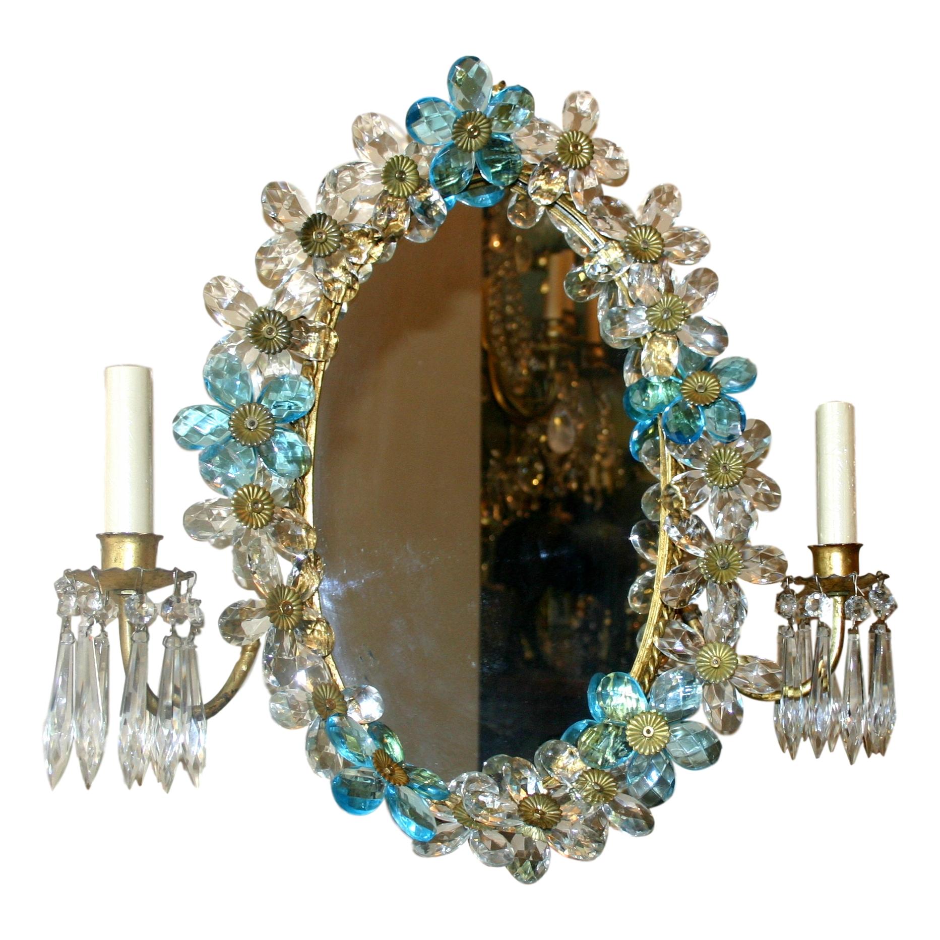 Paire d'appliques à double lumière en métal doré, datant des années 1940, avec plaque arrière en miroir et fleurs en cristal clair et bleu.

Mesures :
Hauteur 18