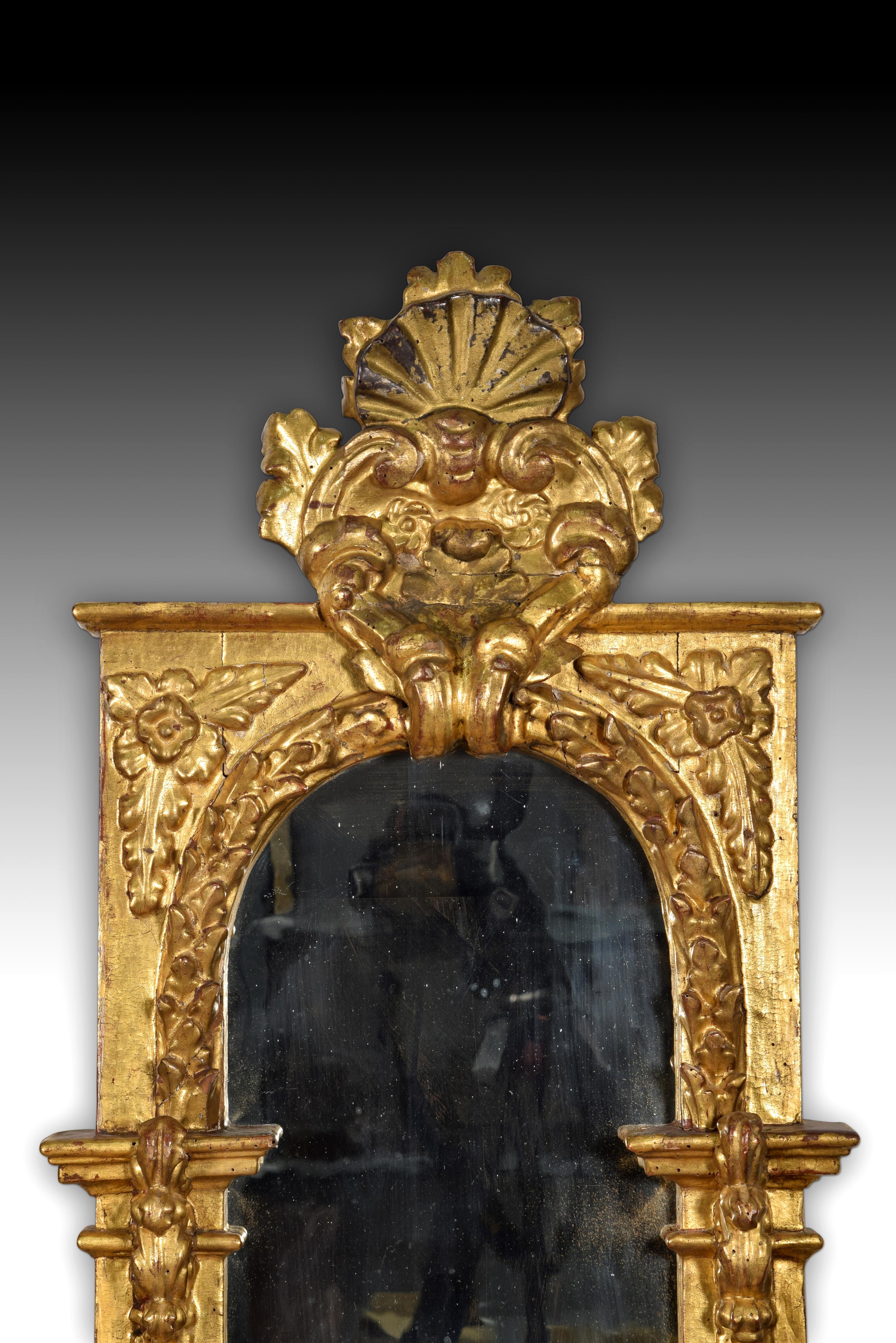 Pair of mirrors. Carved and gilded wood. Spanish school, 18th century.
 Pair of rectangular sheet mirrors with a semicircular arch top that have two carved and gilded wooden frames, very similar to each other. Both have a crest topped with a