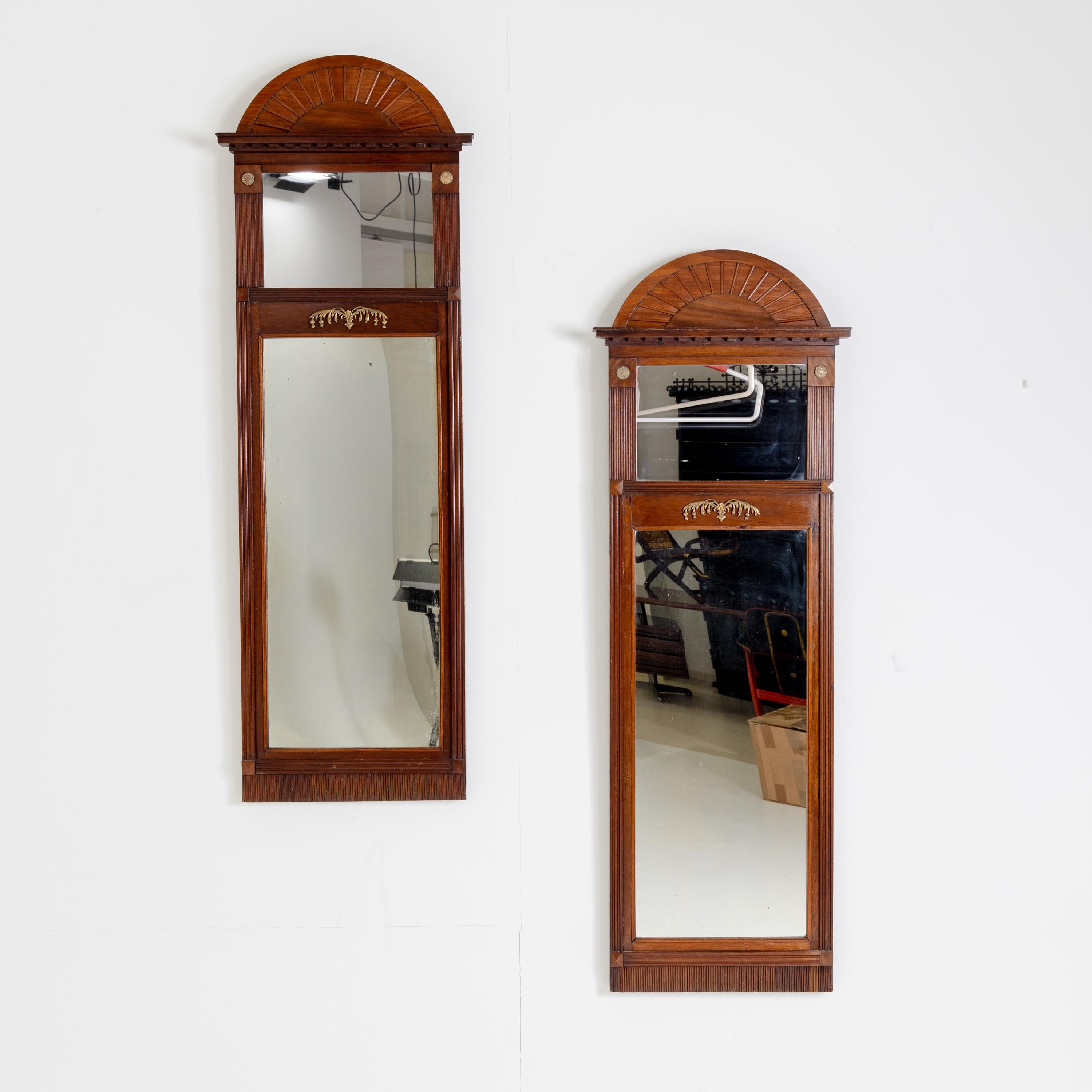 Pair of Danish wall mirrors with segmental pediments and fluted framing made of mahogany.