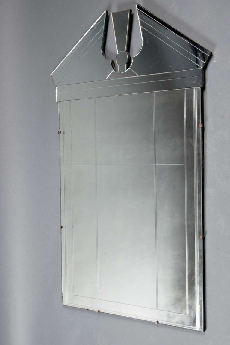 Mirrored glass with an arched top, framed in brass and mirrored tinted glass border. Mirror panels include age marks throughout.