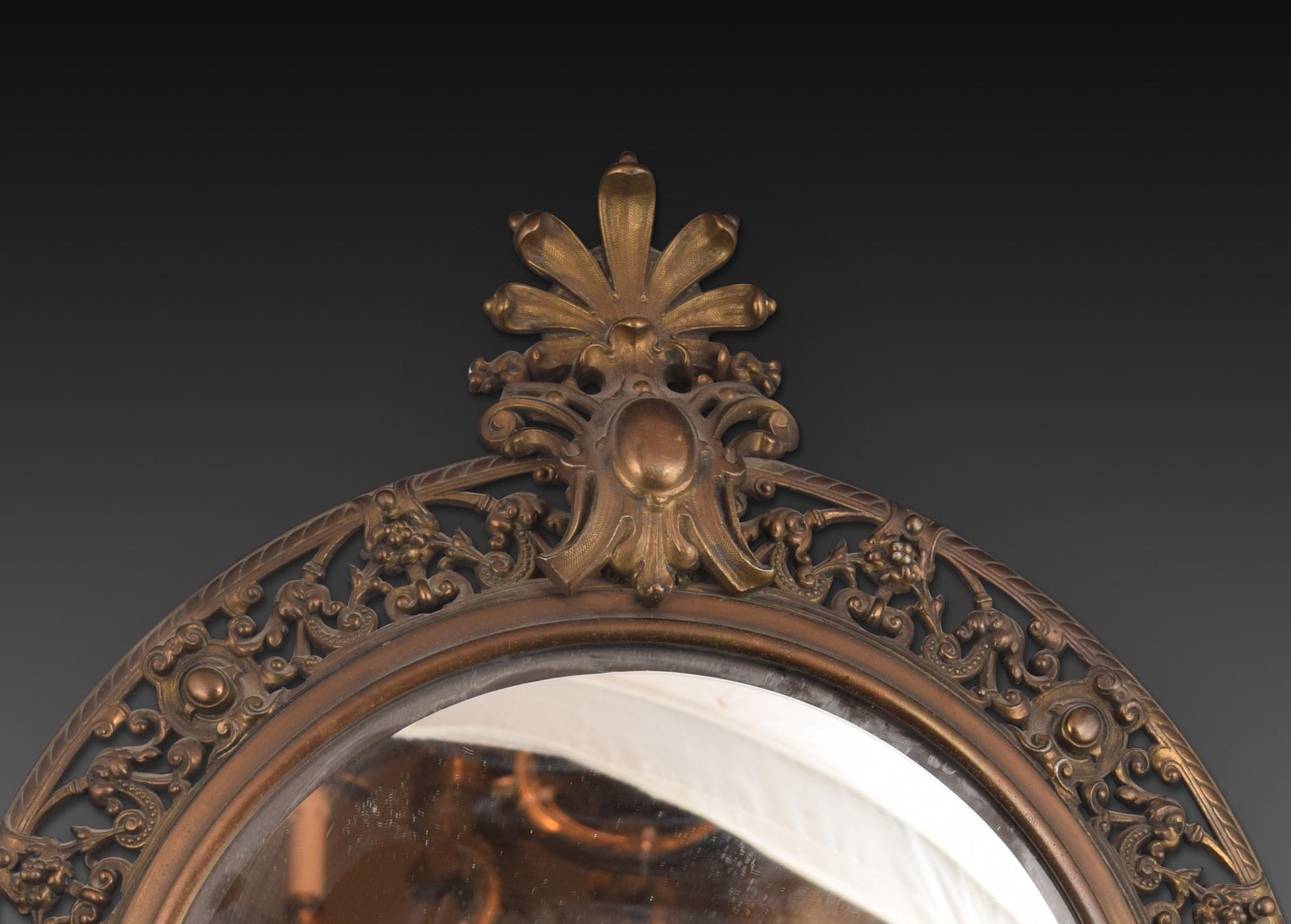 Paire de miroirs avec appliques. Métal, verre. 20e siècle. 
Paire de miroirs muraux à cadre métallique, décorés d'éléments architecturaux et végétaux d'une nette influence classiciste (à noter l'ajourage, le petit écusson situé en haut des deux et