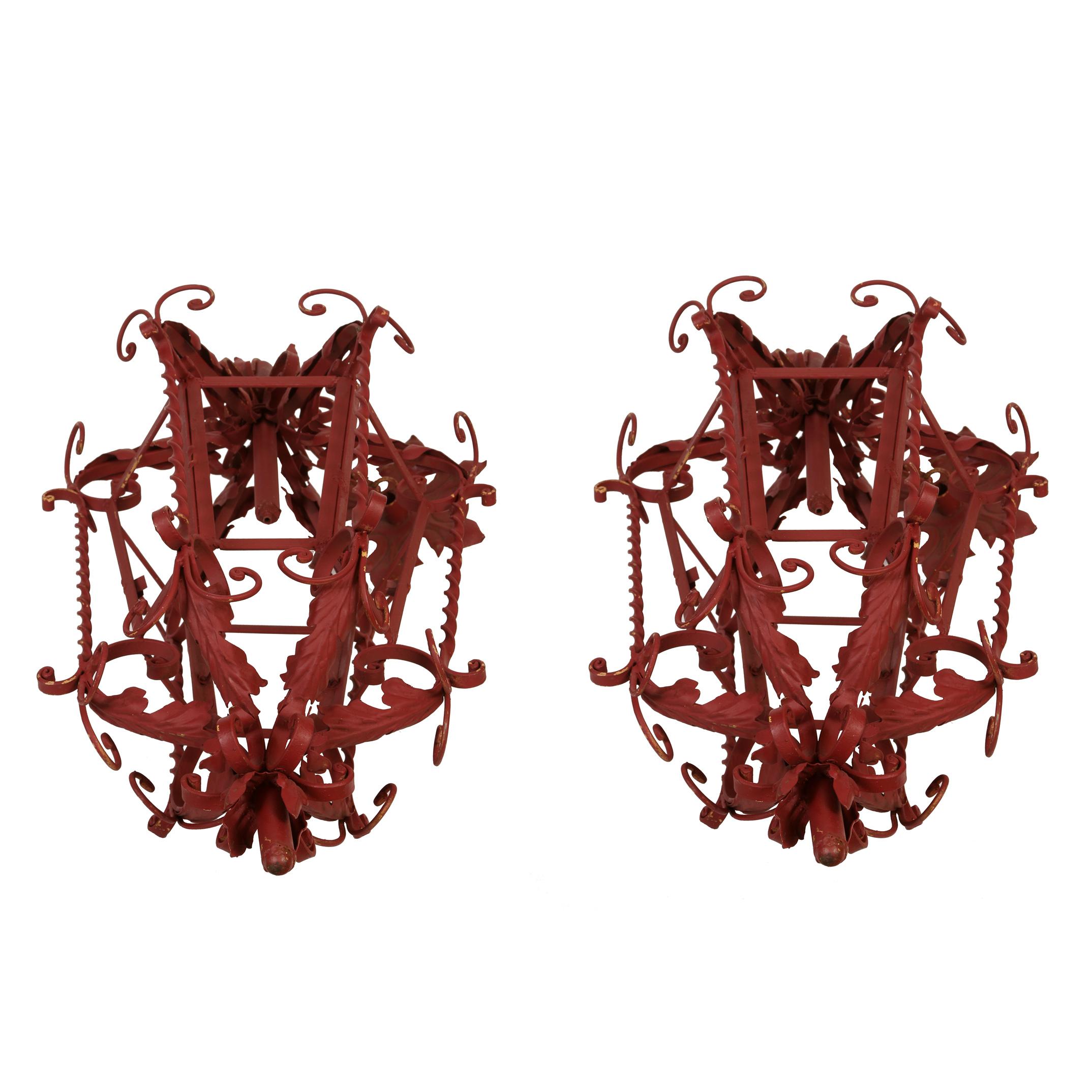 A pair of red painted wrought iron Mizner style non-electrified lanterns.