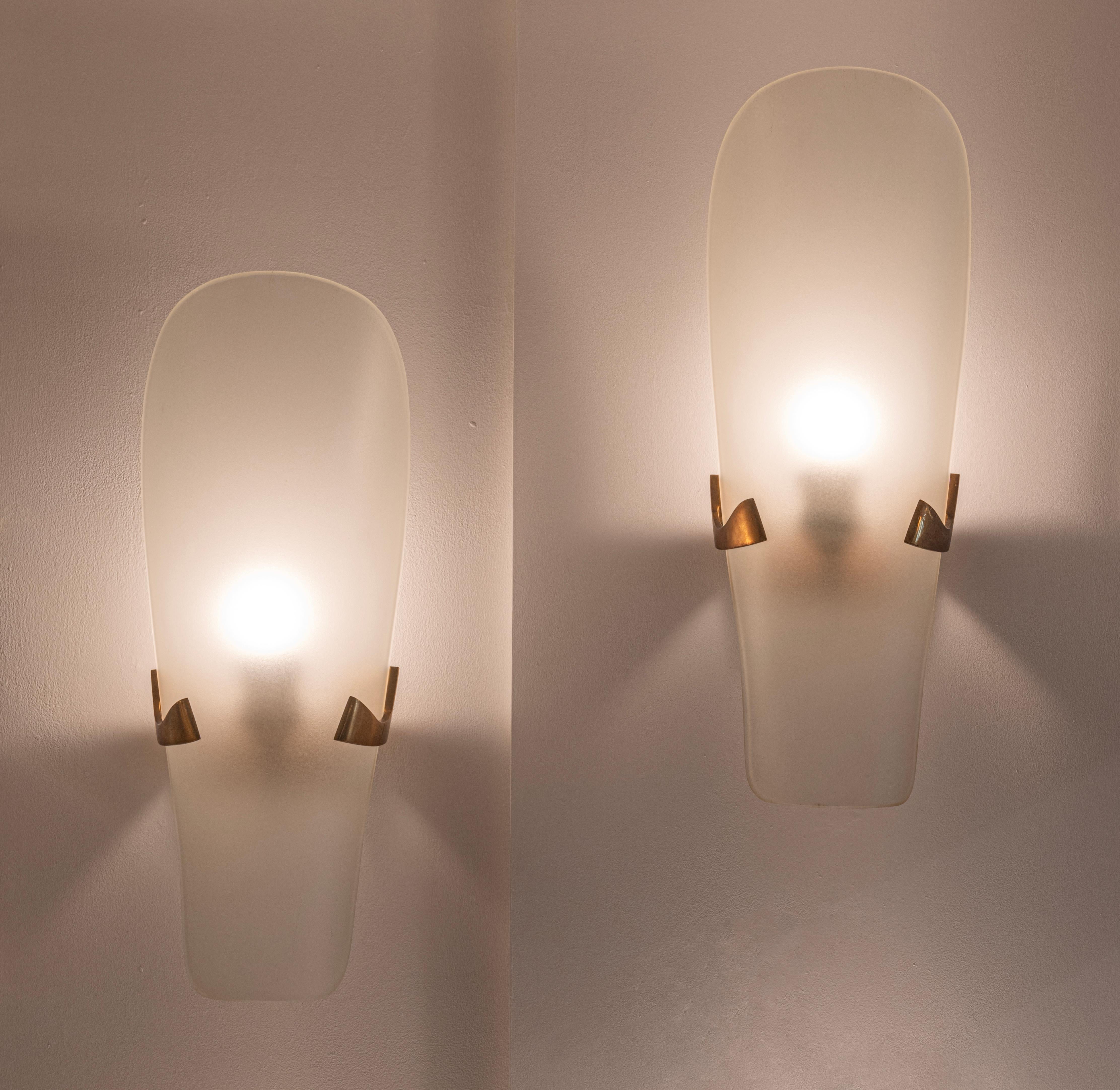 Una pareja original de apliques Mod. 1636 de Max Ingrand para Fontana Arte, Italia, c.1957. Los difusores curvados de cristal grabado al ácido, de diseño sencillo, descansan simplemente entre los brazos de latón de la luminaria. La calidad superior