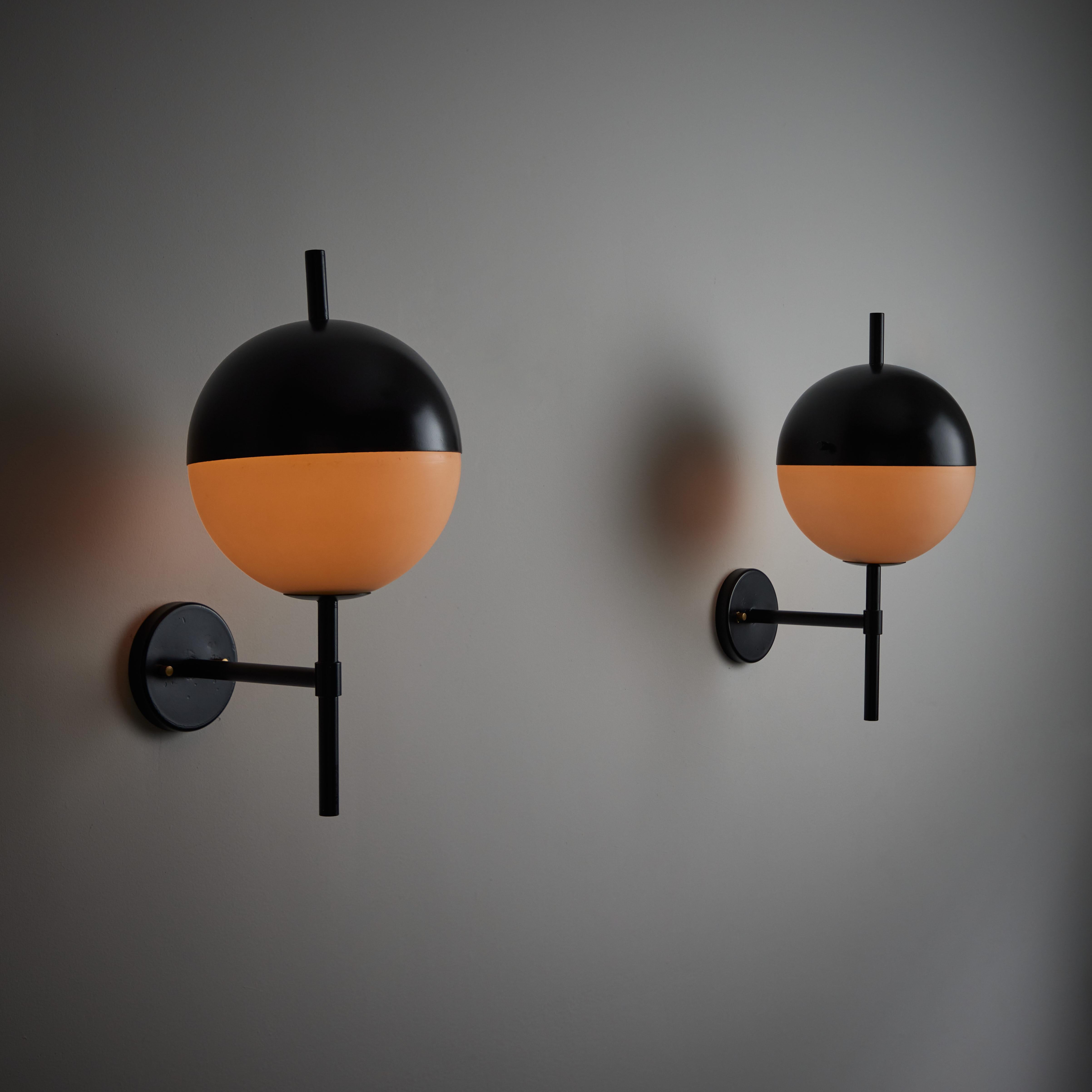 One pair of model 2071 sconces by Stilnovo. Manufactured in Italy, circa 1950s. Half and half black and white opal spheres make up these simply beautiful and unique sconces. Each sconce holds one E27 socket, adapted for the US. We recommend one 40w