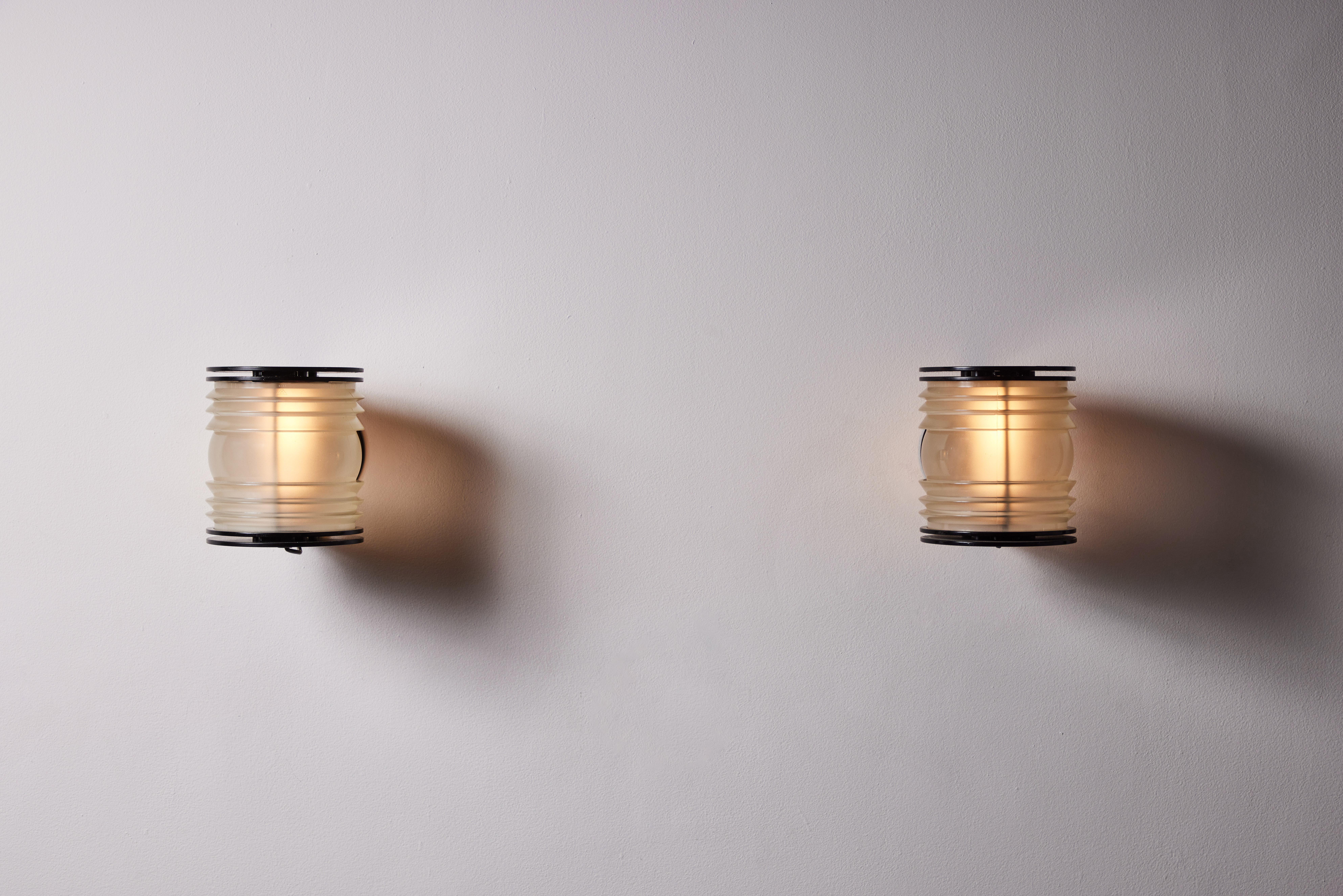 Pair of Model 1139 Fresnel sconces by Joe Colombo for Oluce. Designed and manufactured in Italy, circa 1960s. Fresnel glass, enameled metal. Rewired for U.S. standards. We recommend one E27 60w maximum bulb. Bulbs provided as a one time courtesy.
