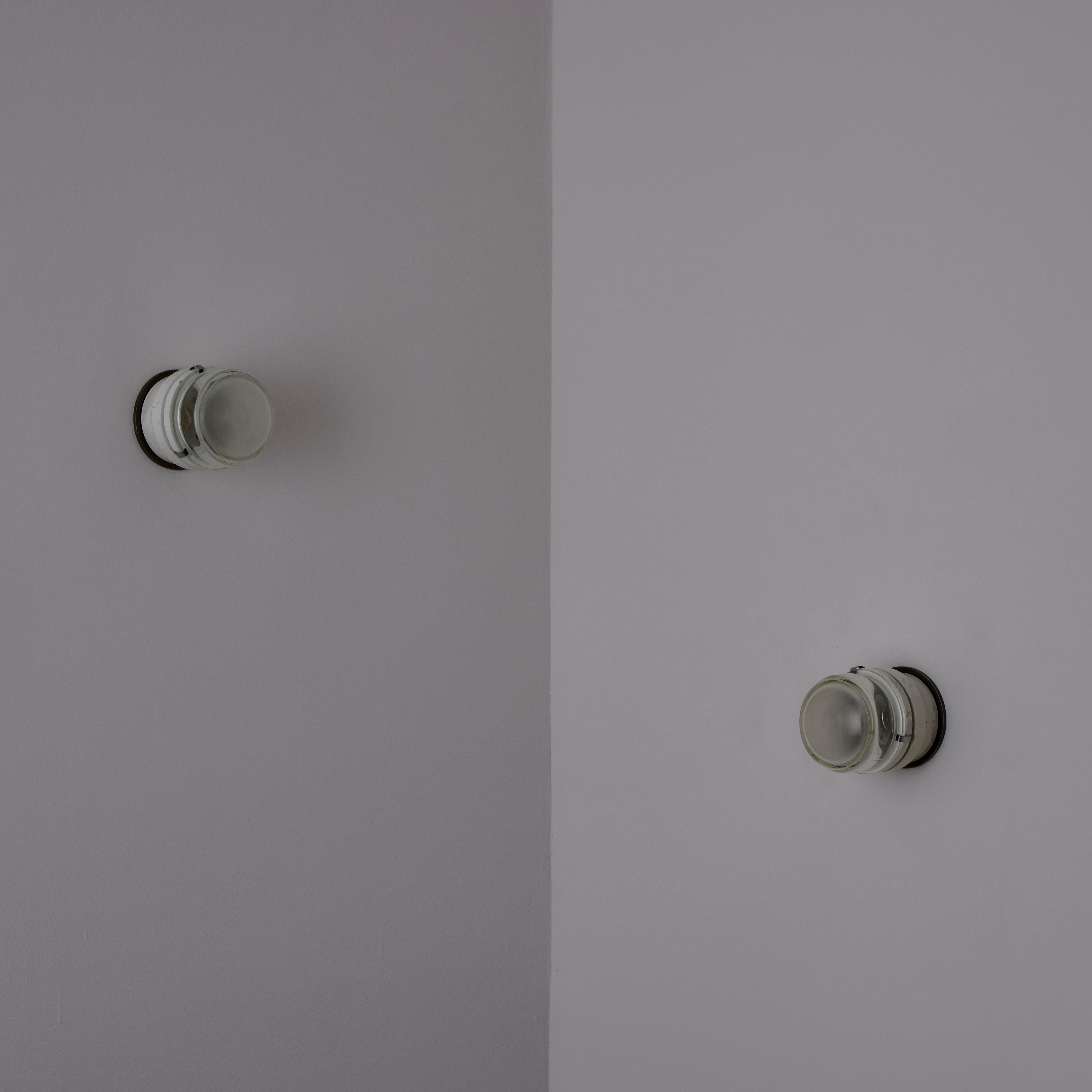 Model 1148 Fresnel wall/ceiling lights by Joe Colombo for O-Luce. Cream colored enamel and a frosted glass diffuser. US flat brass plate for 4