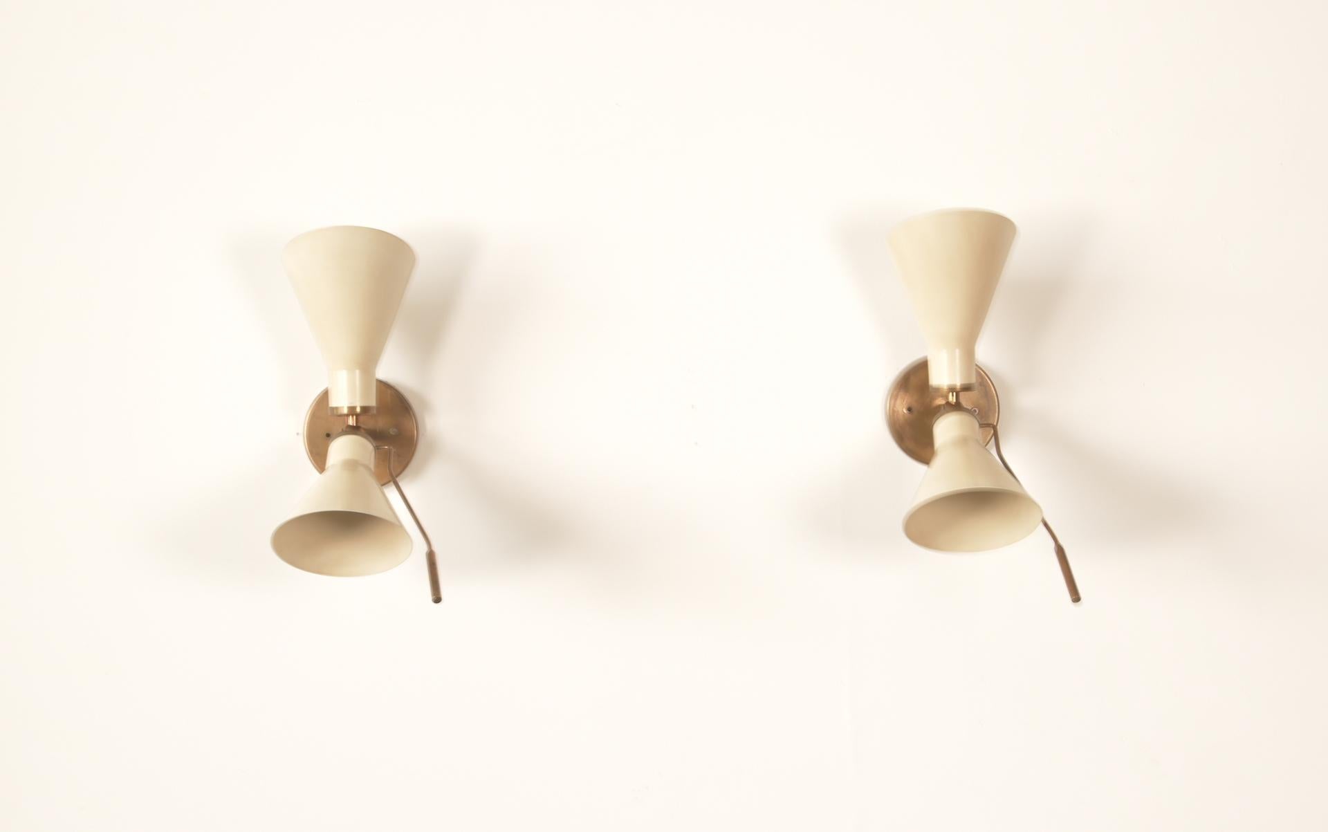 Pair of Model 131 articulating sconces by Gino Sarfatti designed in Italy, circa 1950s. Original backplates.