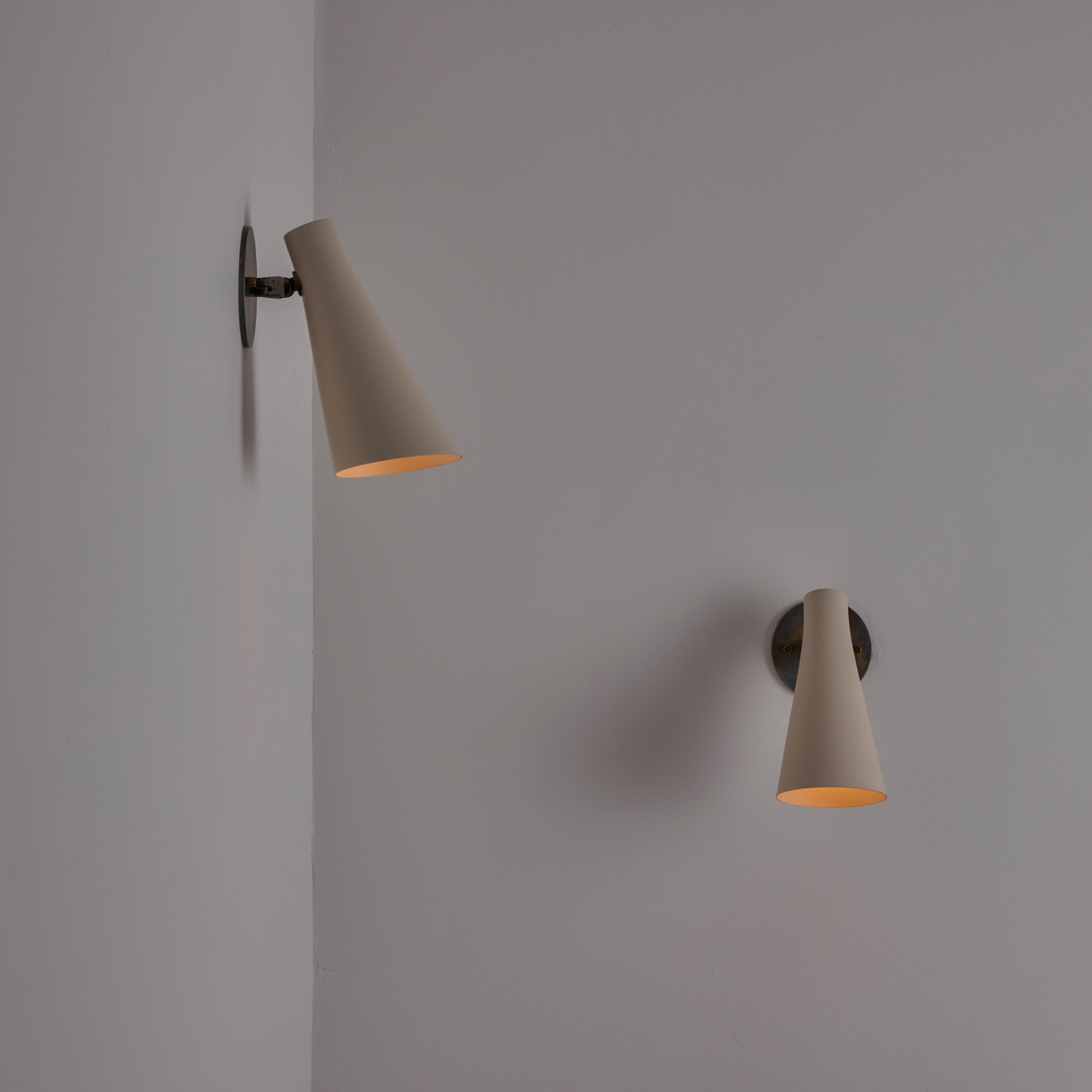 Single Model 138 Sconce by Giuseppe Ostuni for Oluce. Designed and manufactured in Italy, in 1952. Minimal and classic cone sconce with an enamel finish. Pivot coupling located at the base of the mounting plate allowing user to adjust cone shade