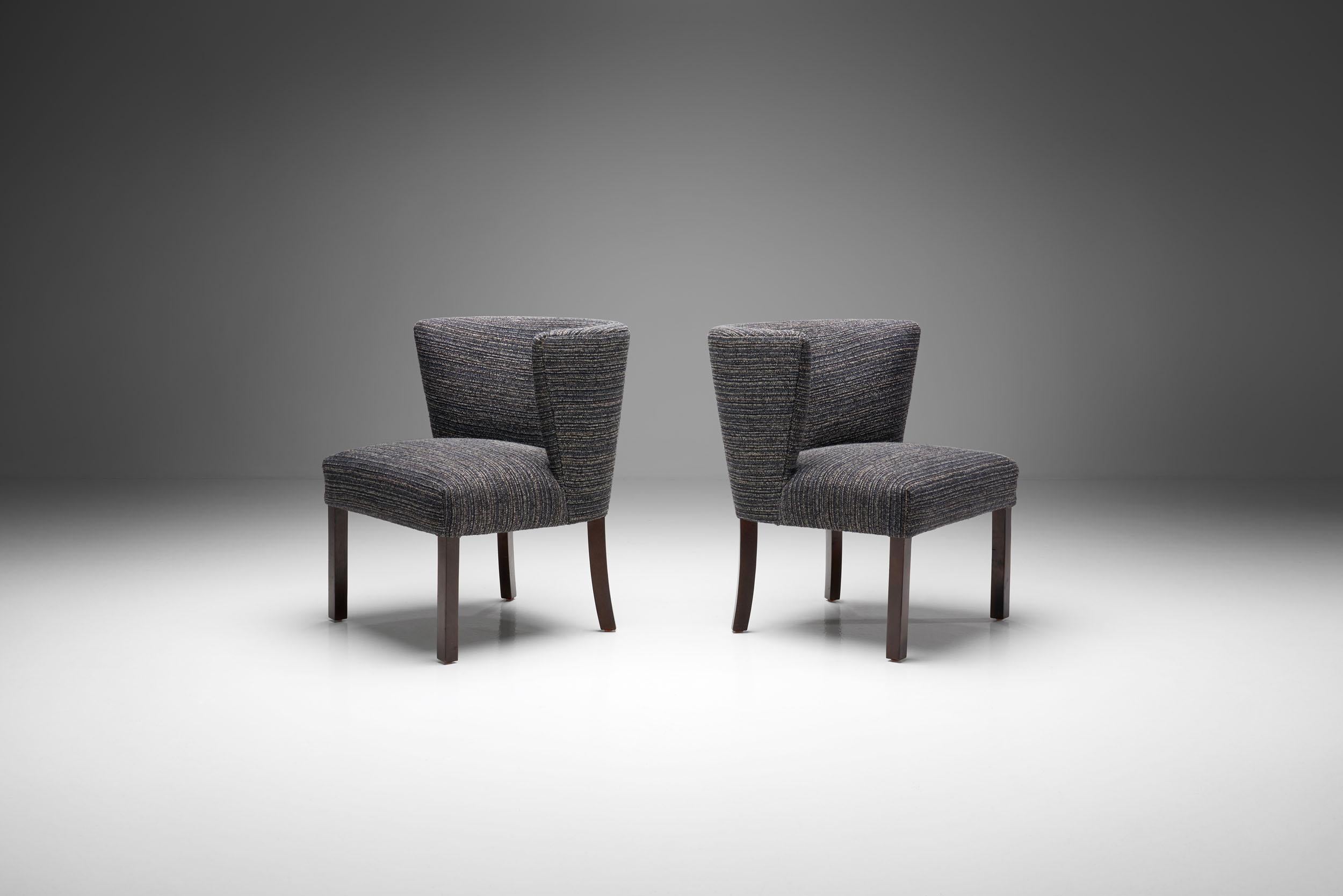 Pair of Model 1514 chairs designed by the eponymous manufactory Fritz Hansen in the 1940s. This pair of lounge chairs feature stained beech legs. The back legs are slightly bent, which is a unique characteristic of Fritz Hansen’s designs. The seats