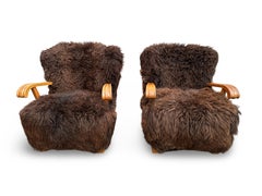 Pair of model 1582 Fritz Hansen loungers in oak and long hair swedish sheepskin.
