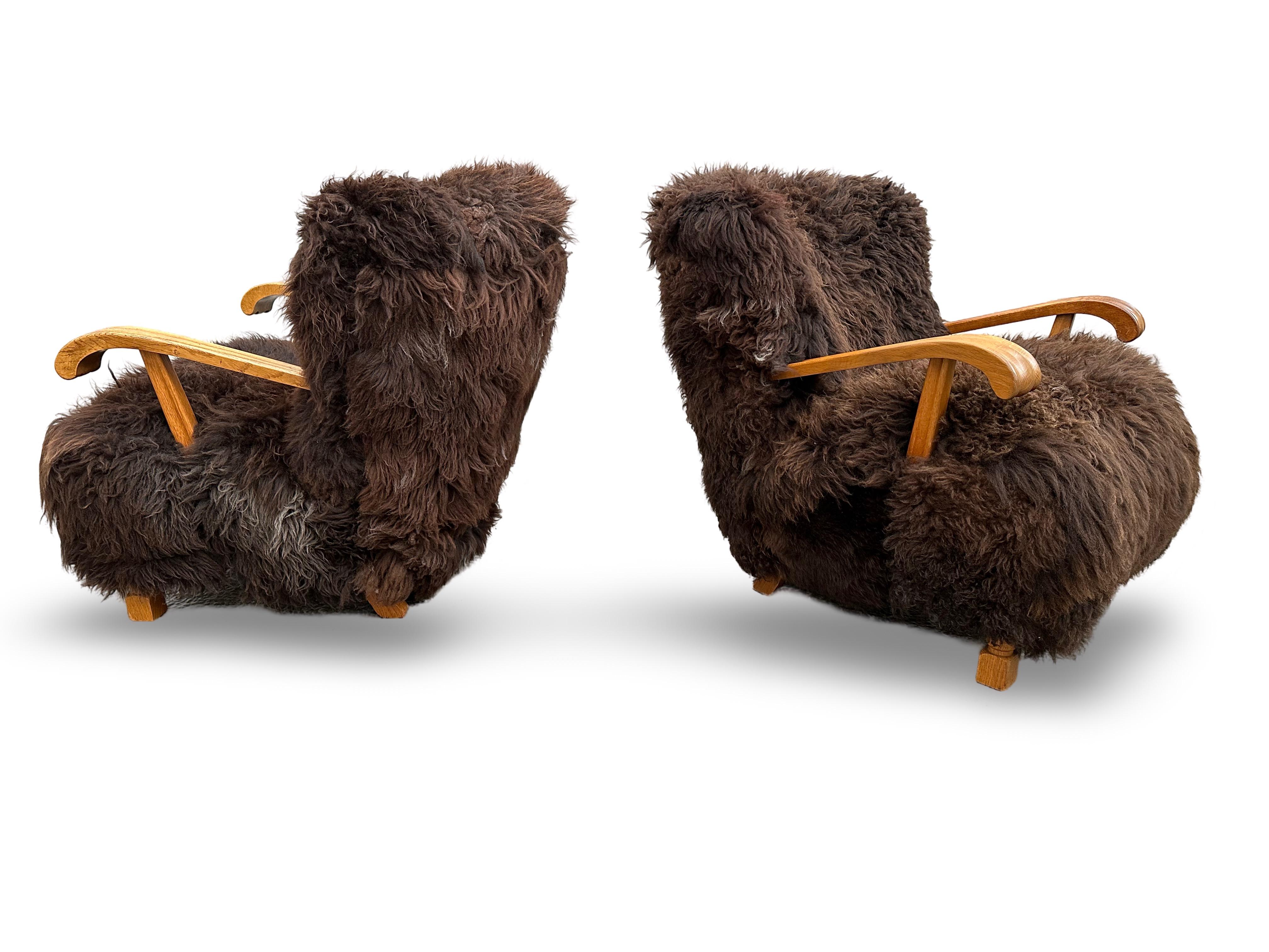 Danois Paire de chaises longues modèle 1582 Fritz Hansen en chêne et peau de mouton suédoise à poils longs. en vente