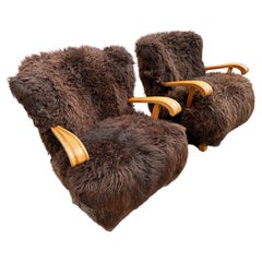 Pair of model 1582 Fritz Hansen loungers in oak and long hair swedish sheepskin.