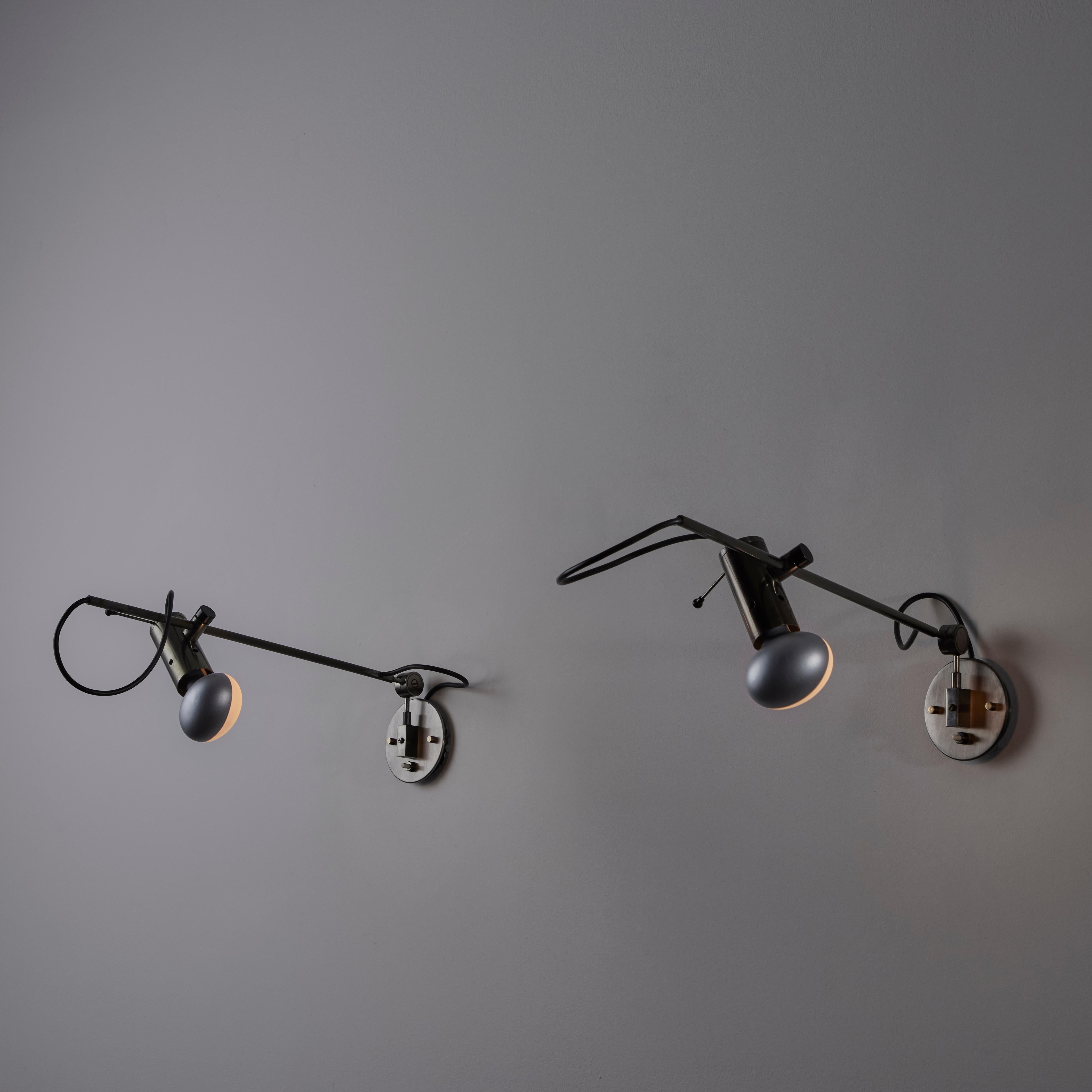 A Pair of Model 194 Sconces by Tito Agnoli for Oluce. Designed and manufactured in Italy, in 1954. Blackened nickel armatures with adjustability on height and light direction. The 