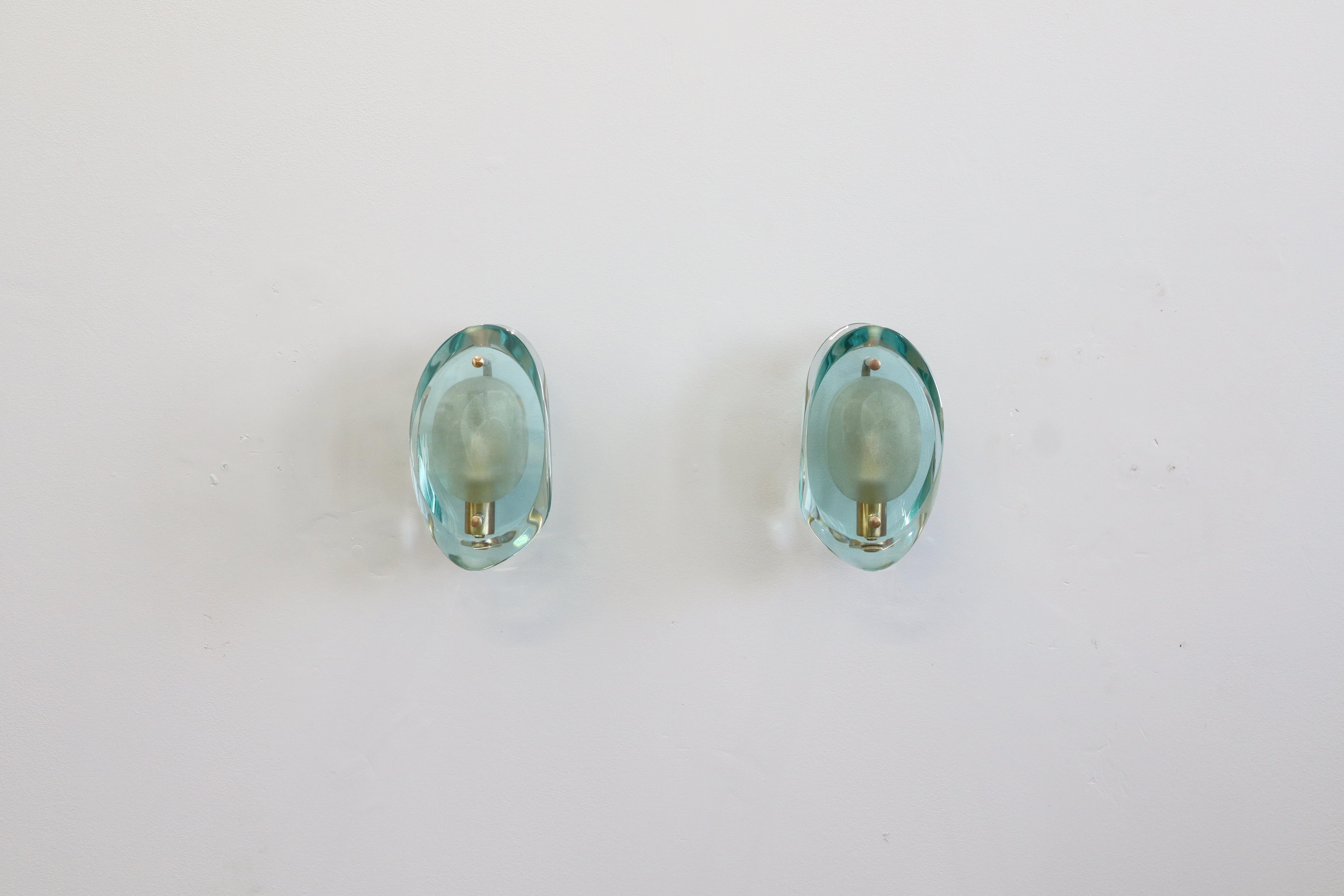 Original-Wandleuchte Modell 2093, geschliffenes Oval in der Mitte und abgeschrägte Seiten auf Messinghalterungen / Entwurf von Max Ingrand für Fontana Arte, ca. 1960er Jahre / Hergestellt in Italien.
verfügbar 3 Satz