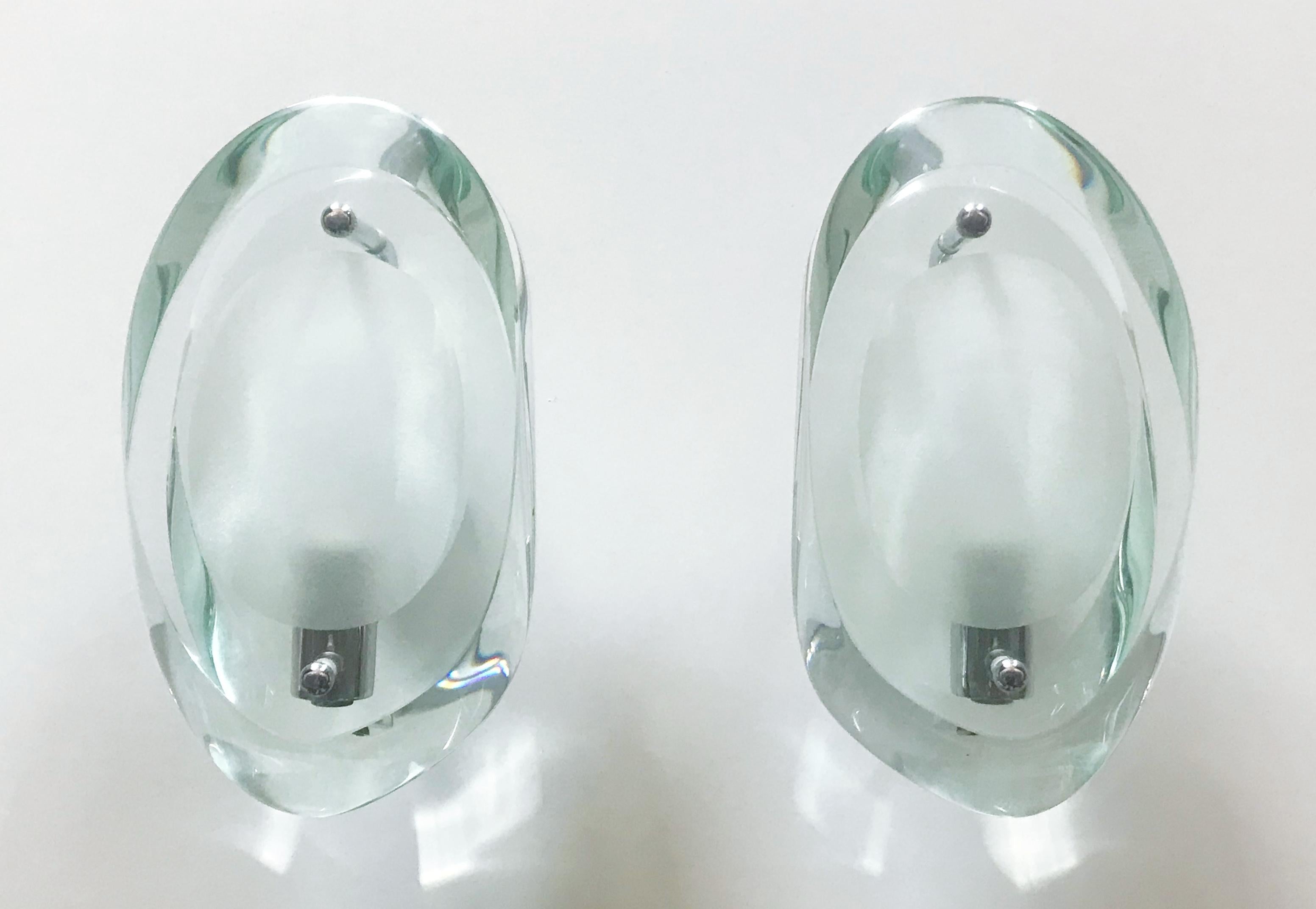 Original model 2093 wall lights with thick bevelled clear glasses, ground oval centre, and bevelled sides held on nickel metal mounts / Designed by Max Ingrand for Fontana Arte, circa 1960s / Made in Italy.
1 light / original E14 type / max 40W