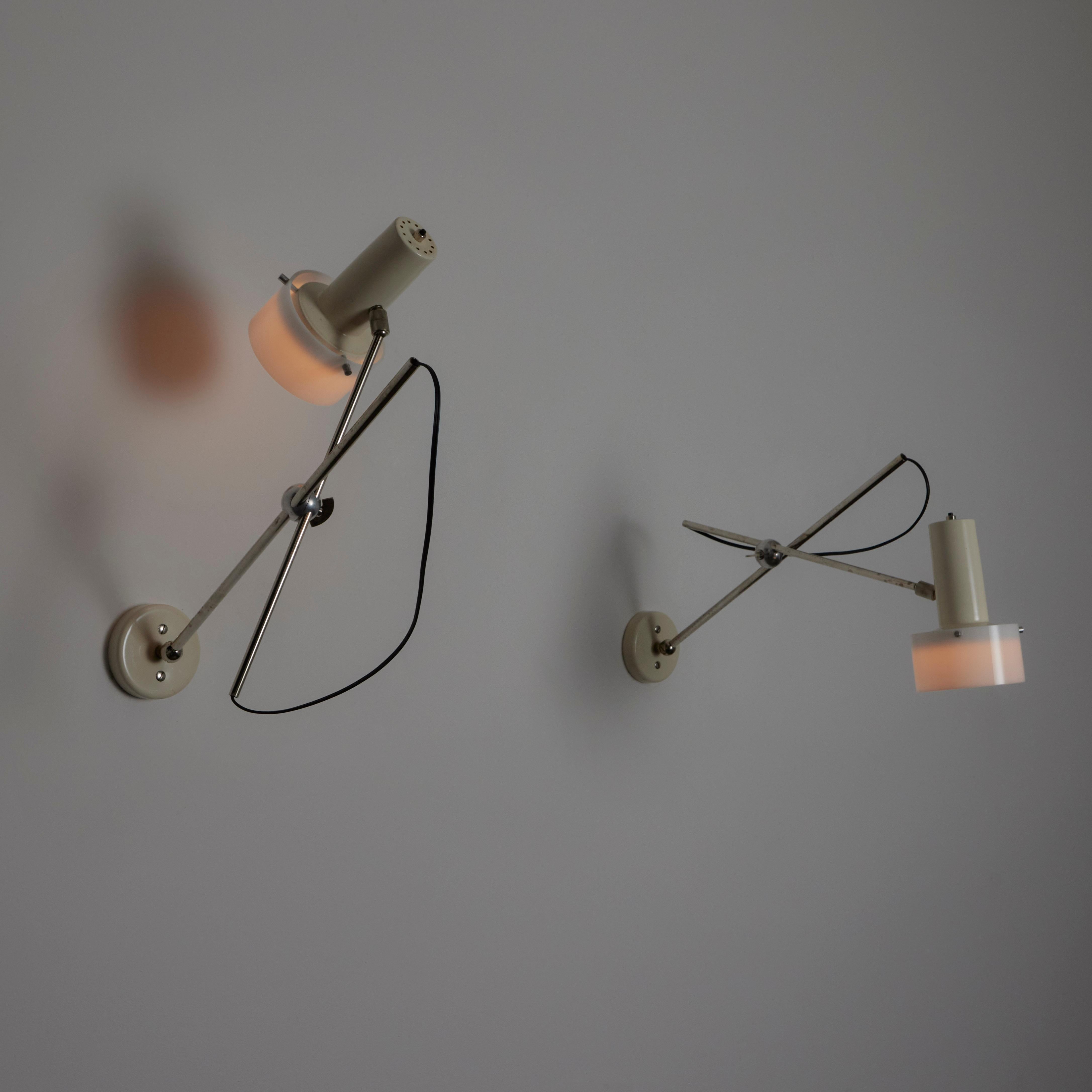 Pair of model 213 Sconces by Gino Sarfatti for Arteluce. Designed and manufactured in Italy, in 1955. Long armed articulating sconces consisting of enamel and acrylic shades and chrome stems. The chrome stems have multi point swivels, allowing for