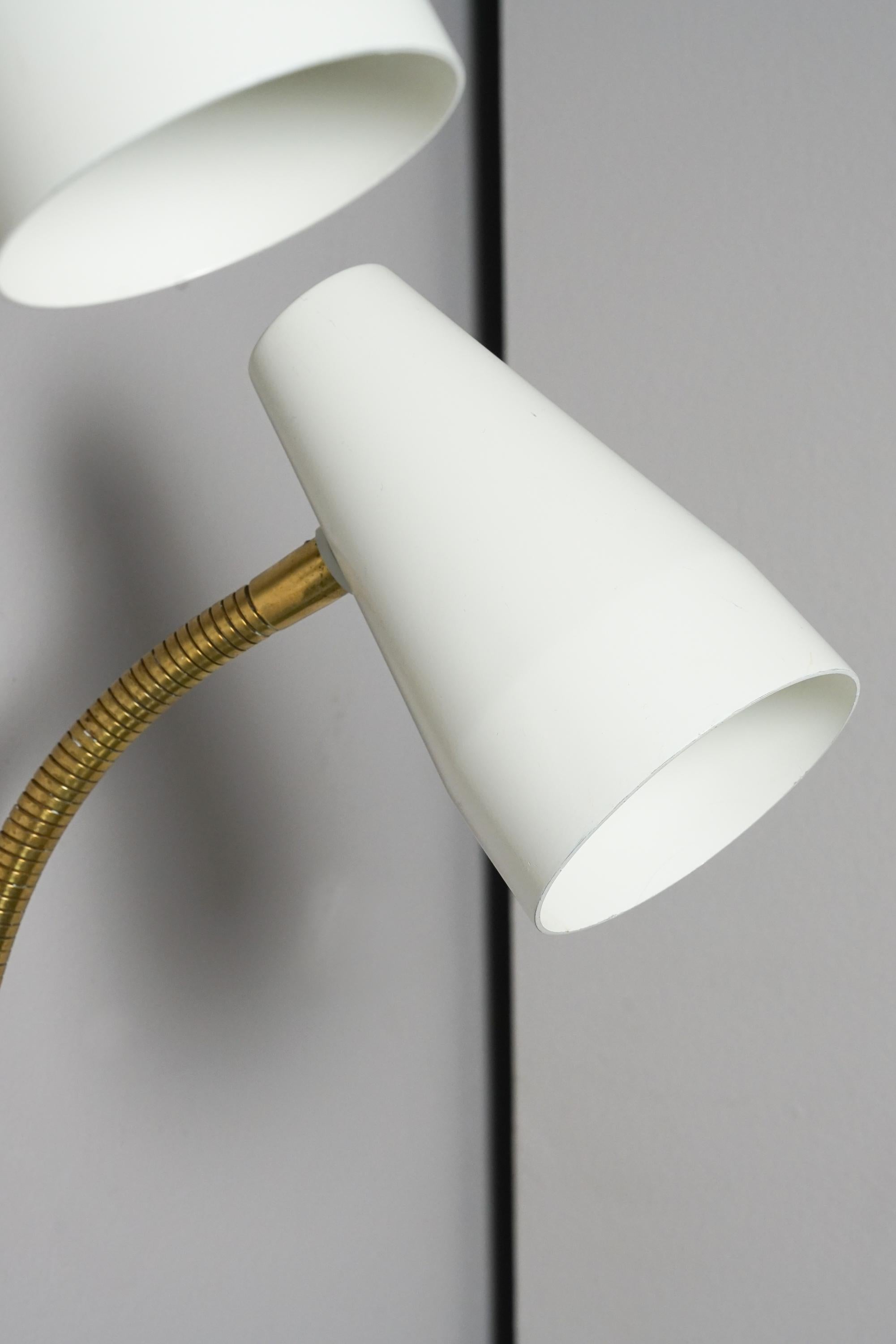 Pair of model 50-056 wall lights, designed by Lisa Johansson-Pape, manufactured by Stockmann-Orno, 1960s. Marked. White painted metal lampshade, brass frame. The lampshade is reversible. Good vintage condition, minor patina consistent with age and