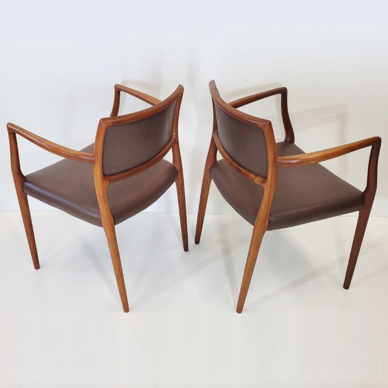 Set of two armchairs, model 65 in solid teak with a rich brown coloured leather. Designed by Niels Otto Møller and manufactured by J. L. Møller factory in the 1960s. 

In fantastic condition, with minor age related markings and signs of