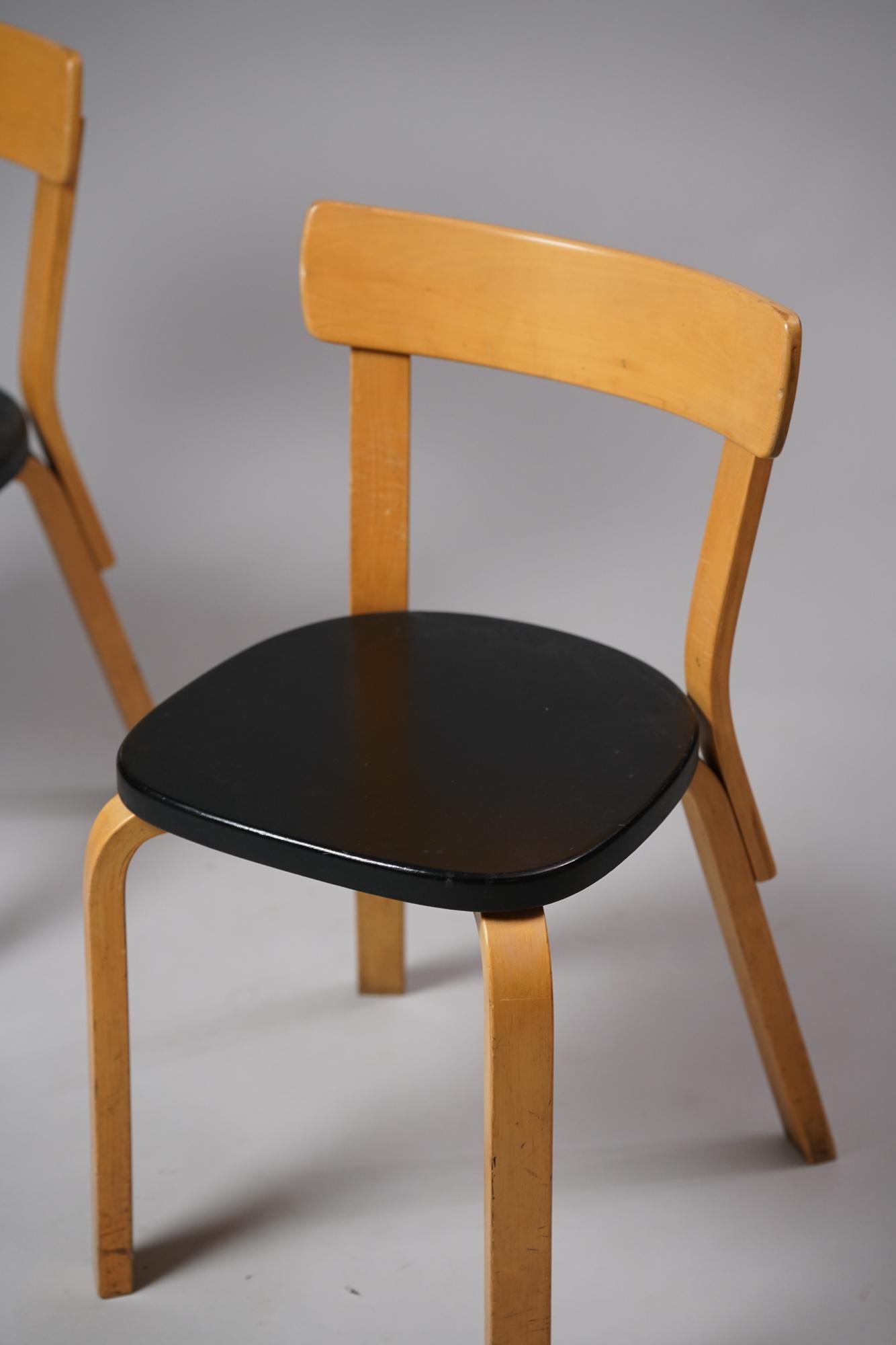 Pair of model 69 chairs by Alvar Aalto for Artek from the 1960s. Lacquered birch with imitation leather seats. Good vintage condition, patina and wear consistent with age and use. Iconic Alvar Aalto design. Suitable for dining chairs as well as desk