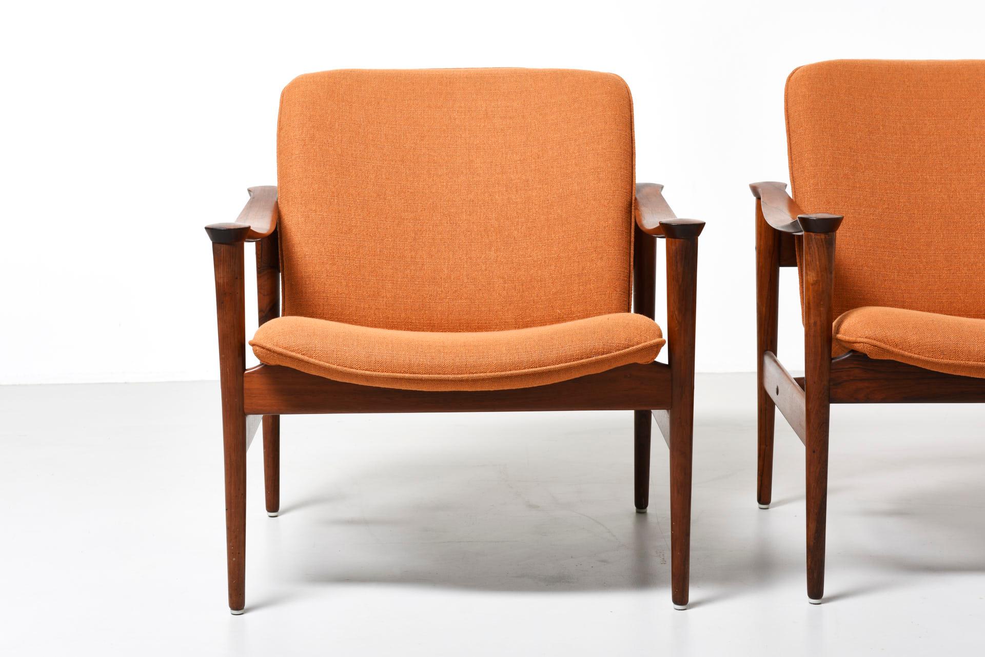 These model 711 armchairs were designed by Fredrik A. Kayser for Vatne Lenestolfabrik in Norway, circa 1958. The chairs feature Brazilian rosewood frames, brass fittings, and light orange fabric upholstery.