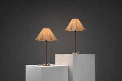 Coppia di lampade da tavolo in ottone e pelle, modello "E1247", per ASEA, Svezia, metà del XX secolo.