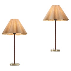 Coppia di lampade da tavolo in ottone e pelle, modello "E1247", per ASEA, Svezia, metà del XX secolo.