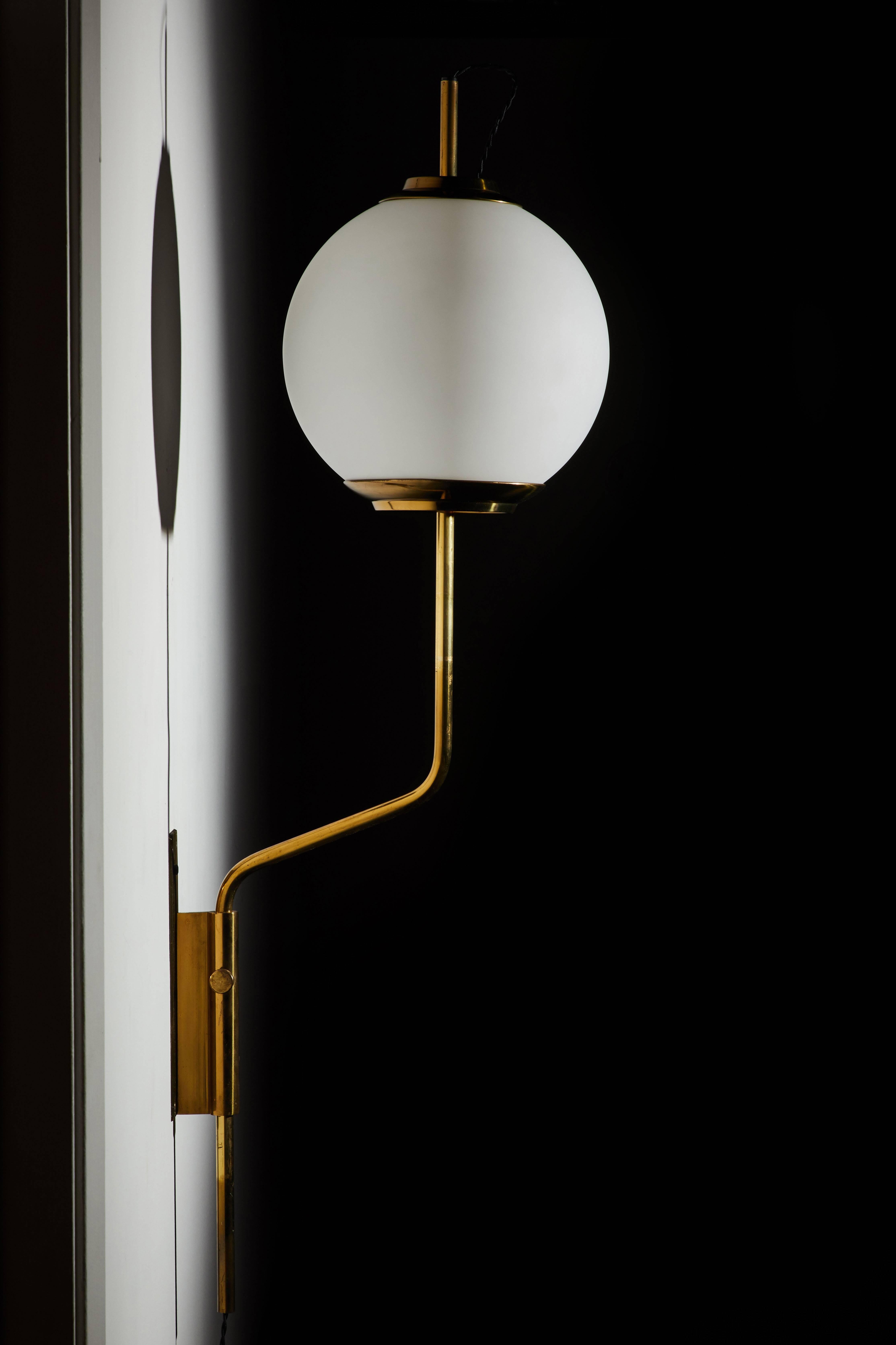 Pair of original model Lp11 pallone wall lights designed by Luigi Caccia Dominioni for Azucena. Manufactured in Italy 1958. Patinated brass and brushed sating glass with vertical positioning that pivots left/right. Original backplates. Wired in
