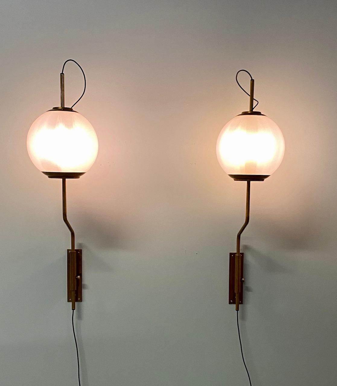 Pair of original model Lp11 Pallone wall lights designed by Luigi Caccia Dominioni for Azucena. Manufactured in Italy, 1958.
Patinated brass and brushed sating glass with vertical positioning that pivots left/right. Original backplates.