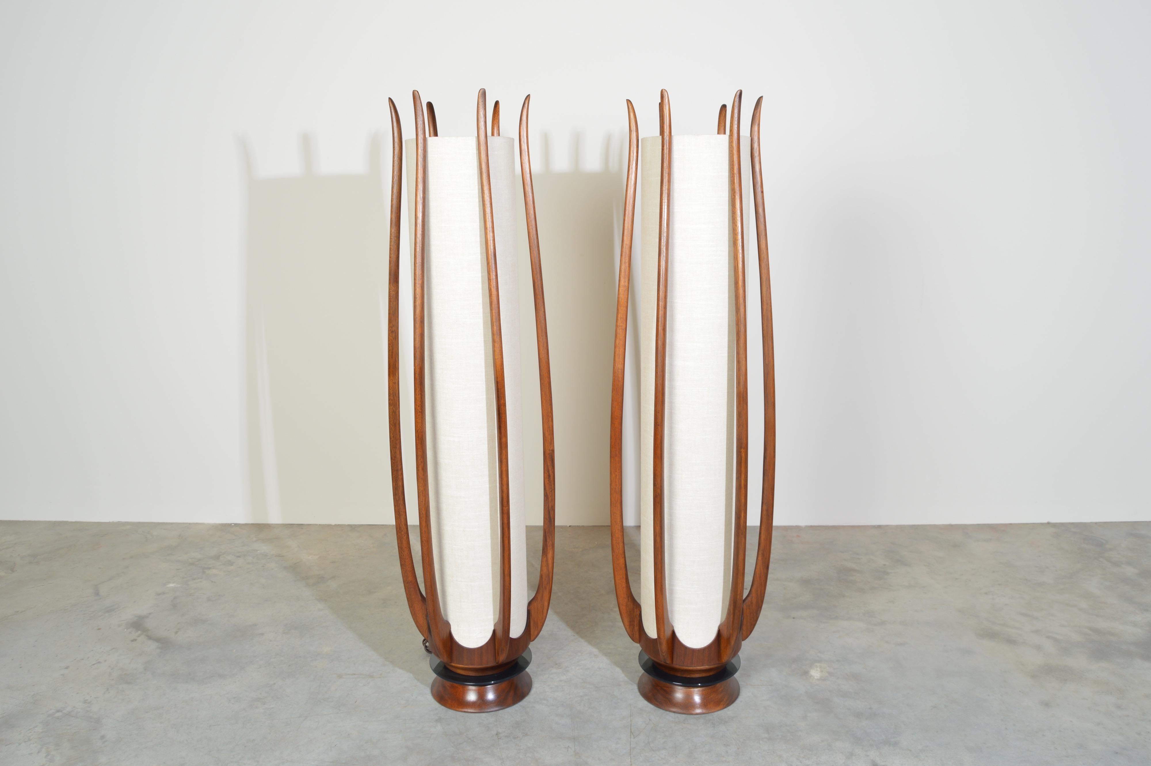 A beautiful pair of mid-century sculptural walnut floor lamps by Modeline Lamp Co. having step switches that can turn the top bulb on/off, the bottom bulb on/off or both bulbs together on/off. 
 In outstanding condition having new wiring and