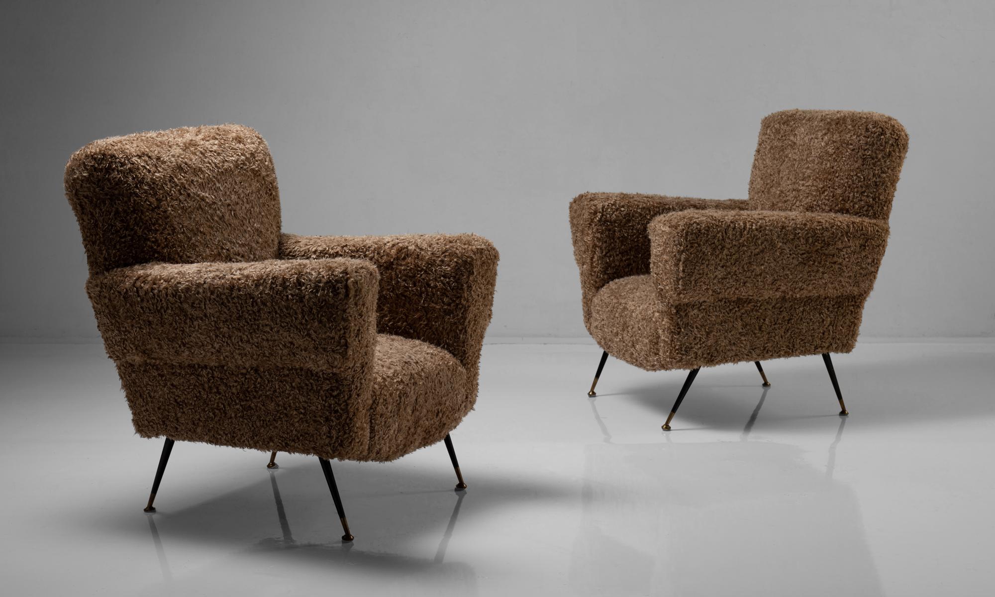 Pair of modern armchairs in faux wool, Italy, circa 1950 

On splayed metal legs with brass feet.