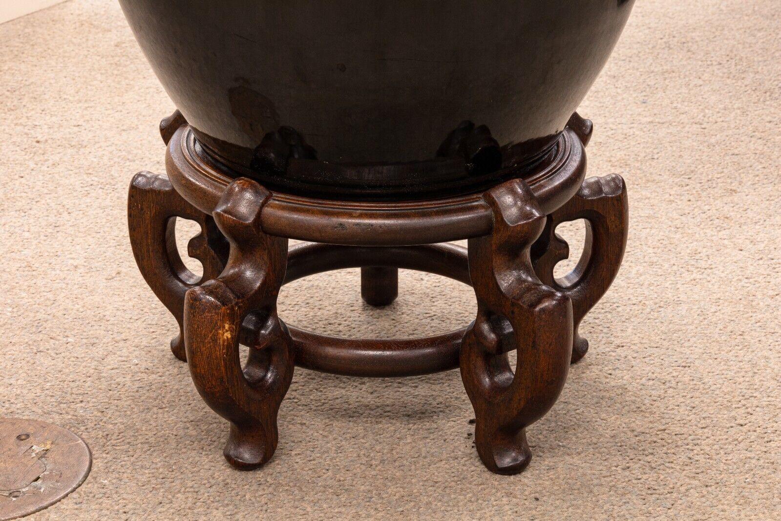 Paire de vases d'urne asiatiques modernes en céramique émaillée noire sur socle en bois orné en vente 1