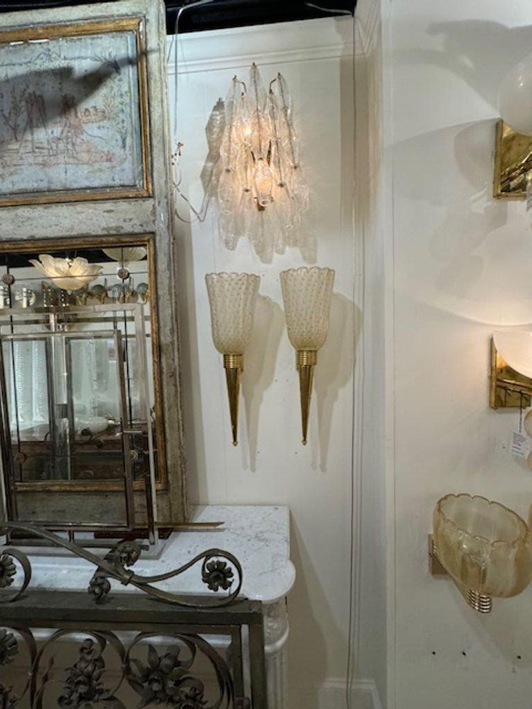 Jolie paire de cônes modernes en laiton et verre de Murano  appliques. Joli verre translucide à pois dorés. Idéal pour un look design !
22h x 7w x 8d