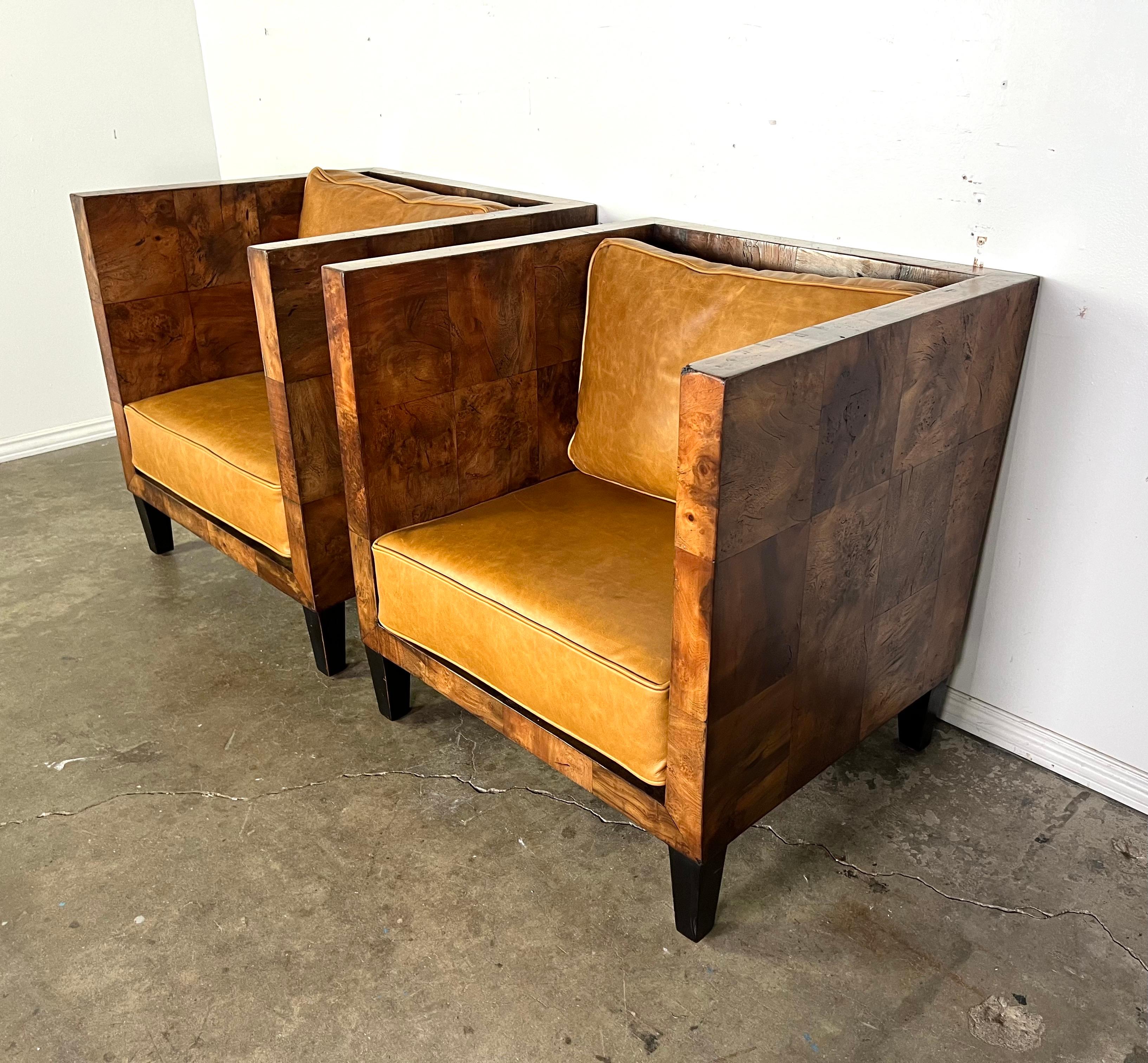 Coppia di poltrone moderne in stile scatola dal design minimalista ma deciso.  Le sedie sono caratterizzate da riquadri di impiallacciatura in radica di noce. Ogni sedia è dotata di spessi e soffici cuscini sciolti per la seduta e lo schienale.  I